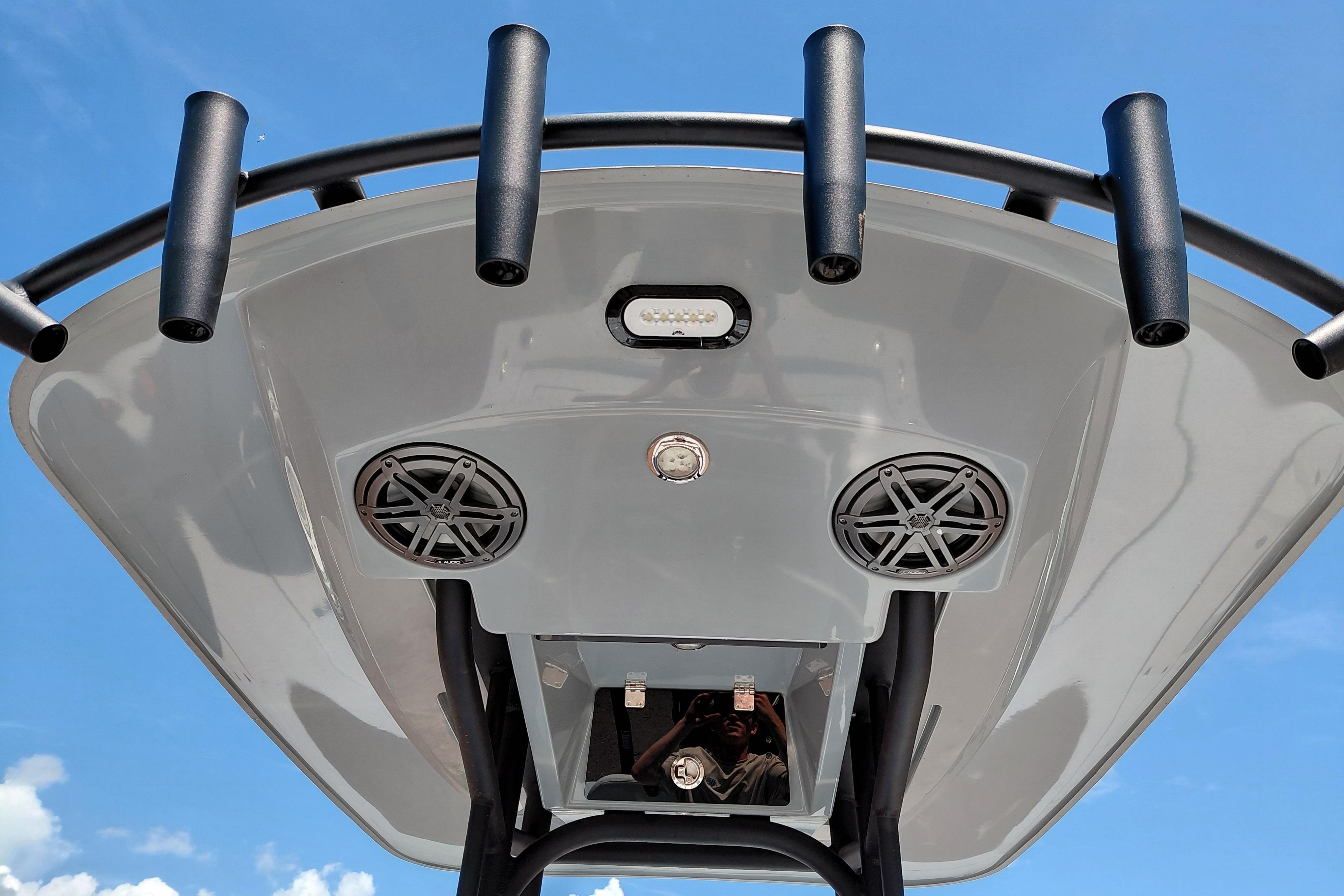 2022 Pathfinder 2300 HPS boat top view with speakers and rod holders against blue sky.