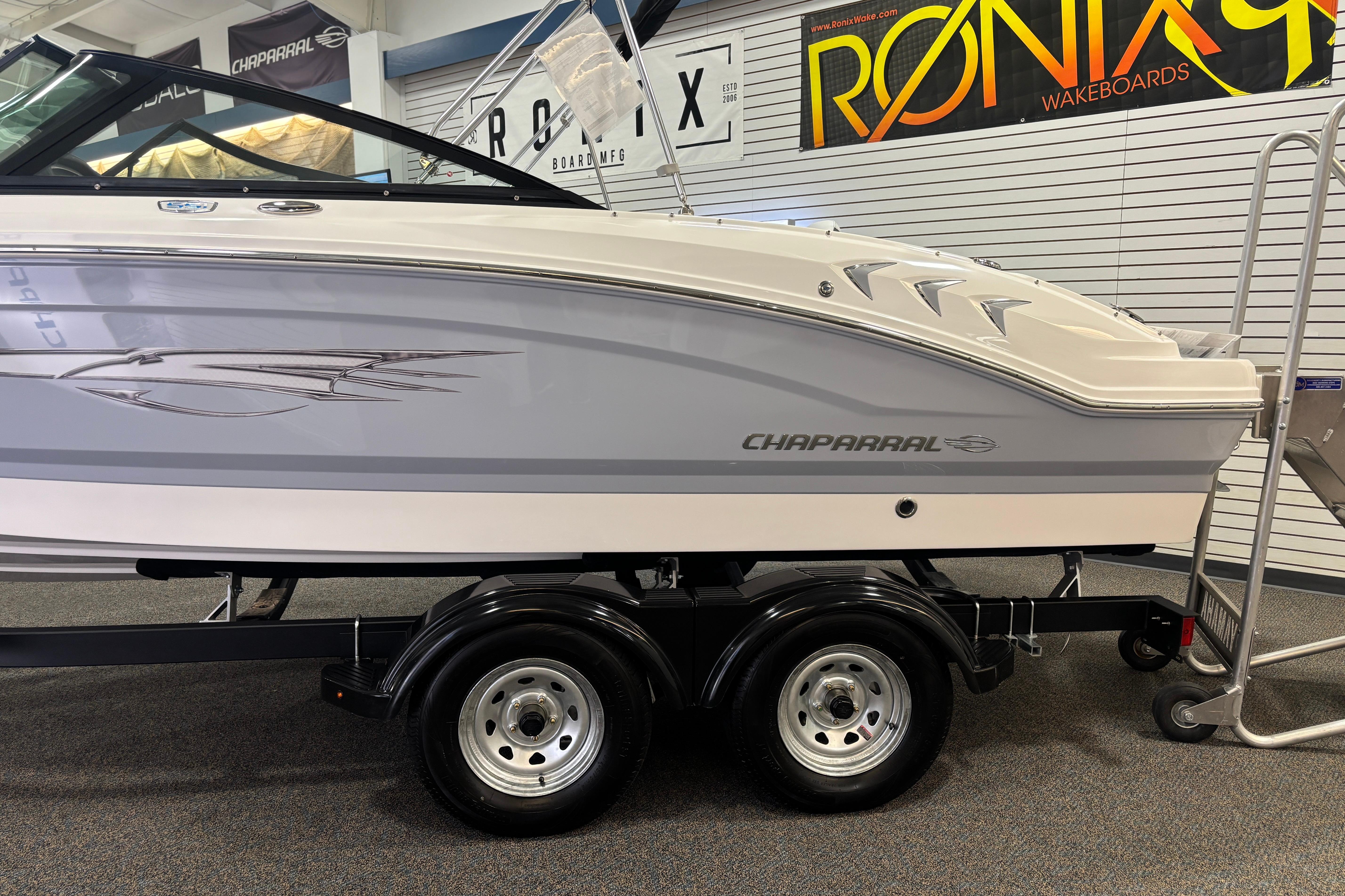 2026 Chaparral 21 SSi Ski & Fish boat on trailer in showroom.
