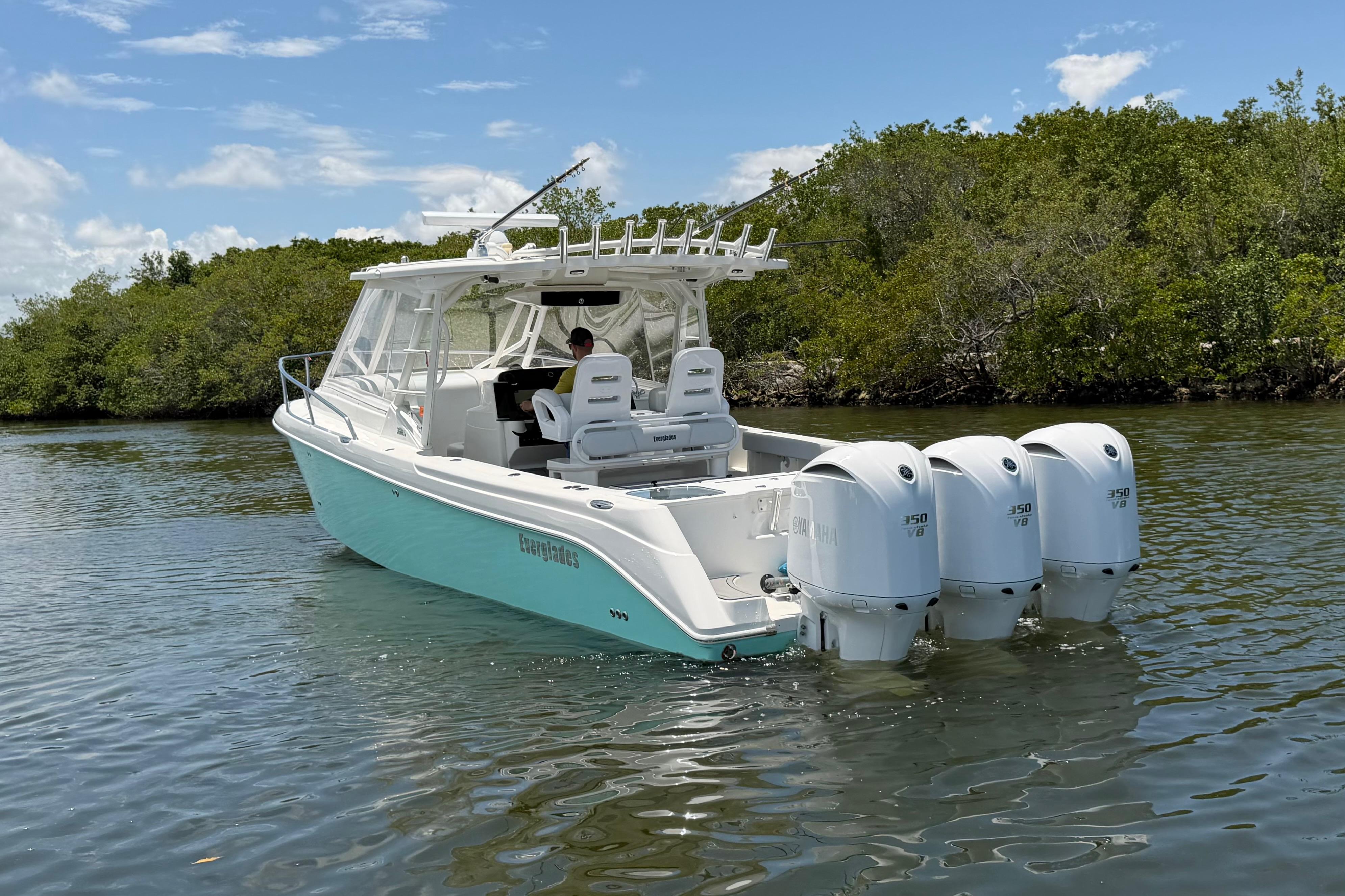 2009 Everglades 350LX boat with triple Yamaha engines on a calm waterway.
