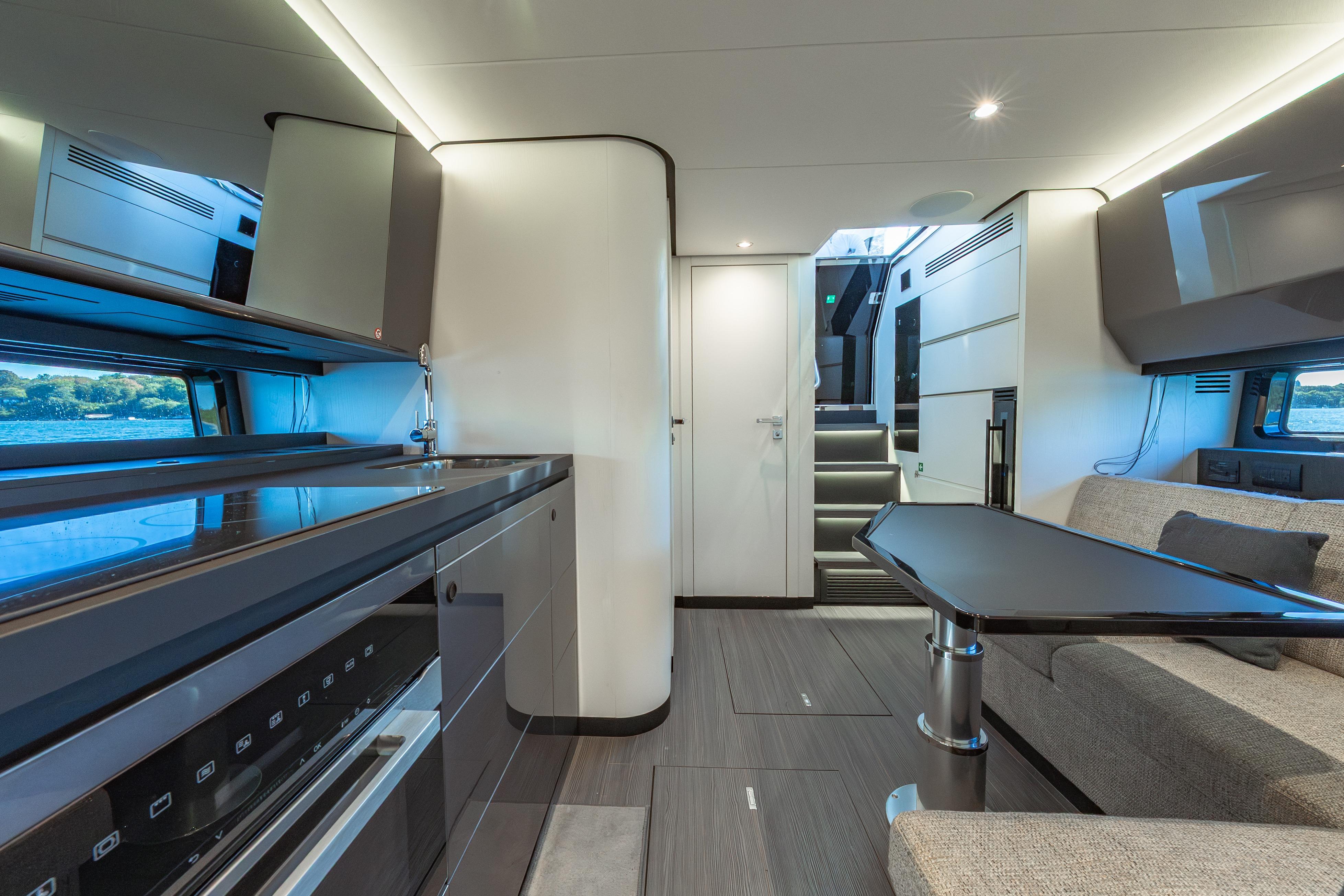 Luxurious interior of 2023 Azimut Verve 47 yacht, featuring modern kitchen and seating area.