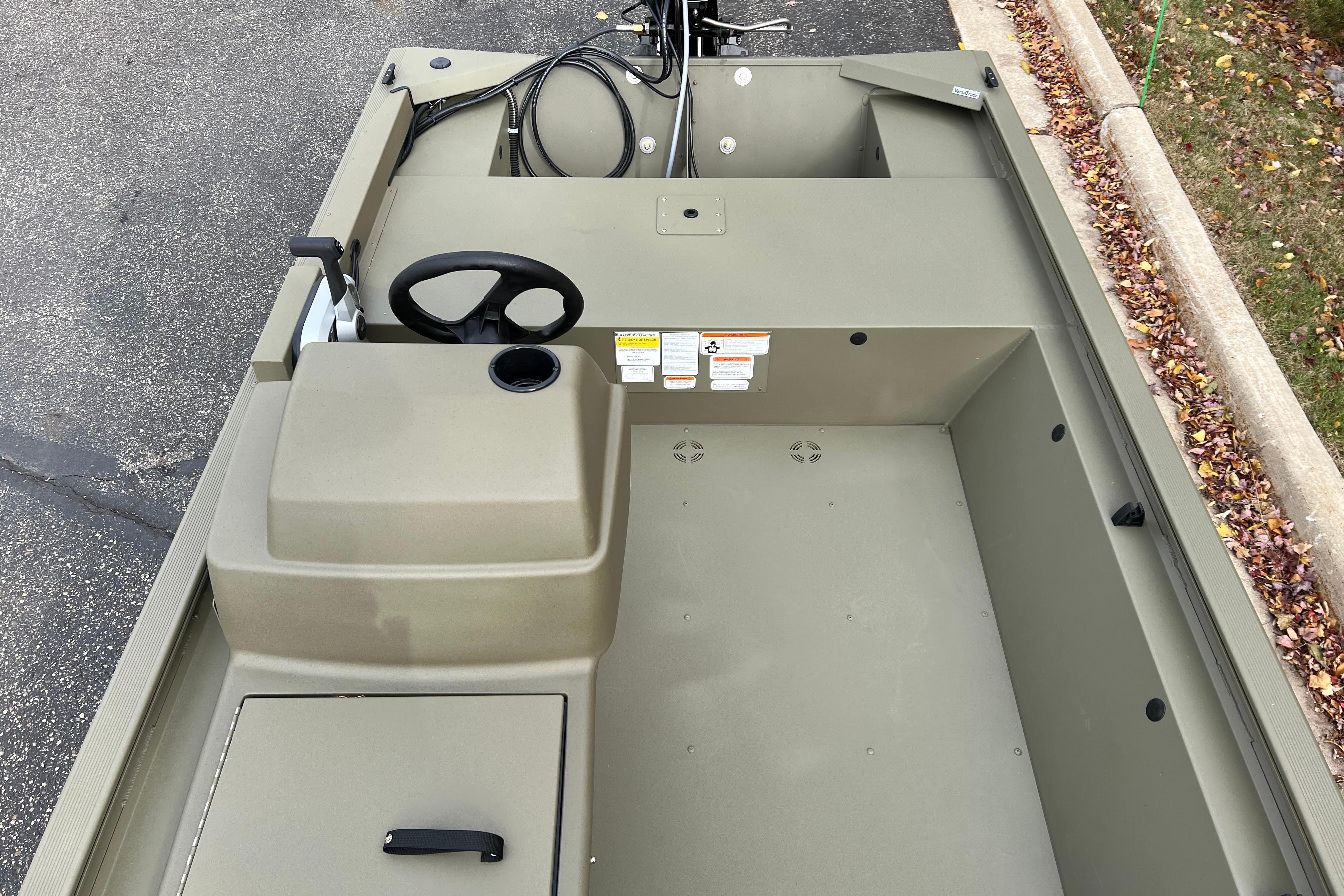 2026 Tracker Grizzly 1648 SC boat interior with steering wheel and storage compartment.