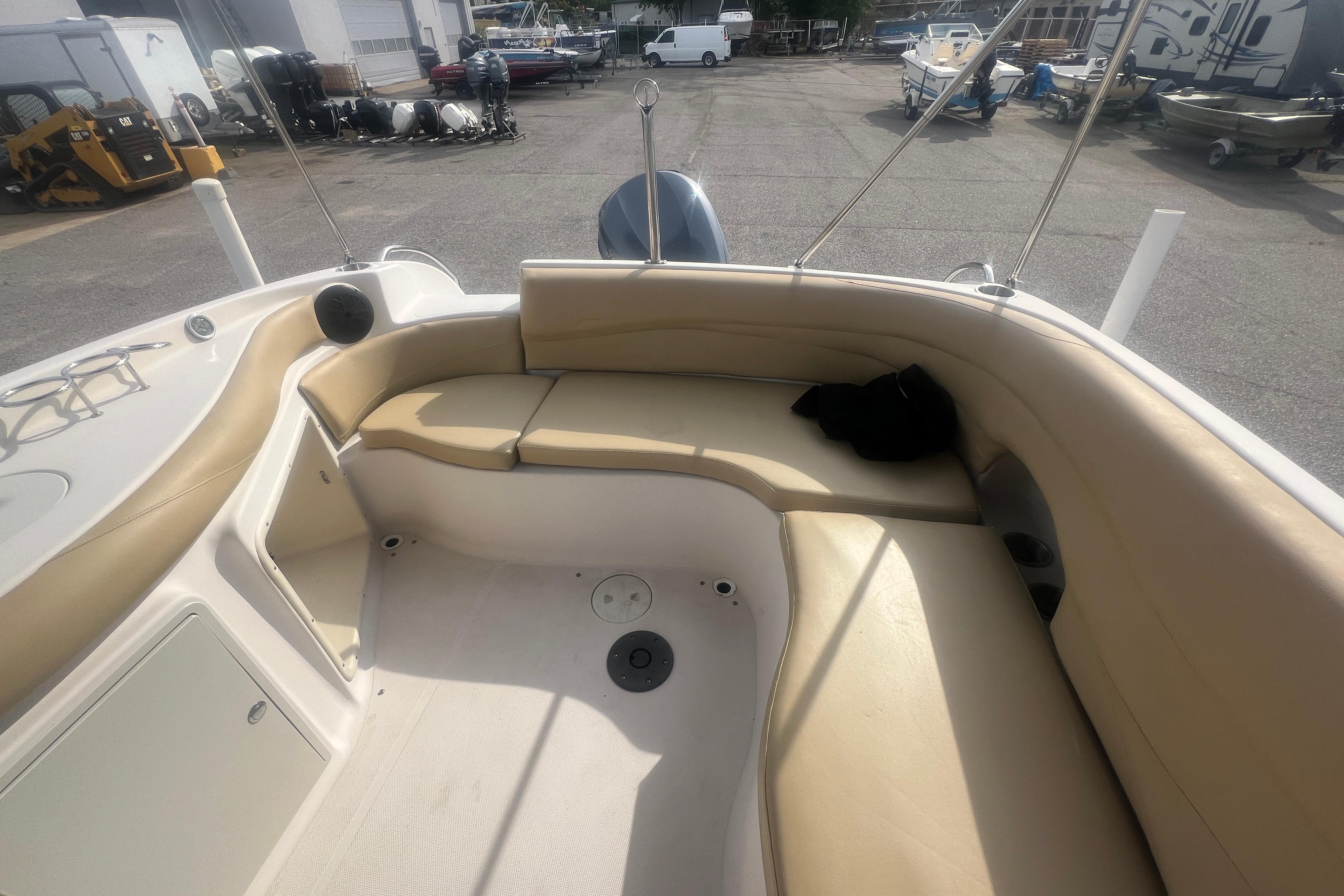 2002 Hurricane SunDeck 260 OB boat interior with beige seating in a marina setting.
