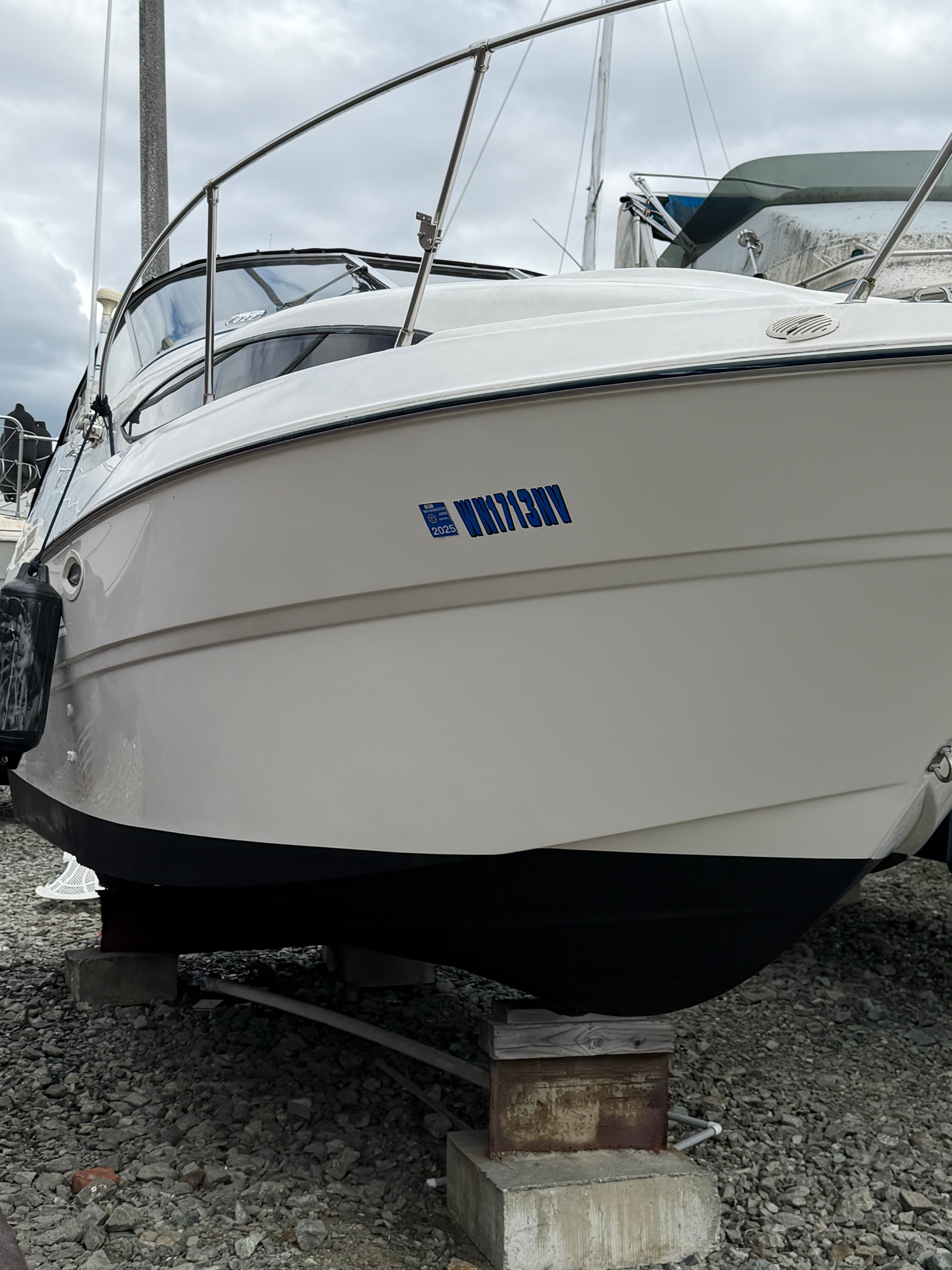2005 Bayliner Cierra 245 boat propped on gravel.