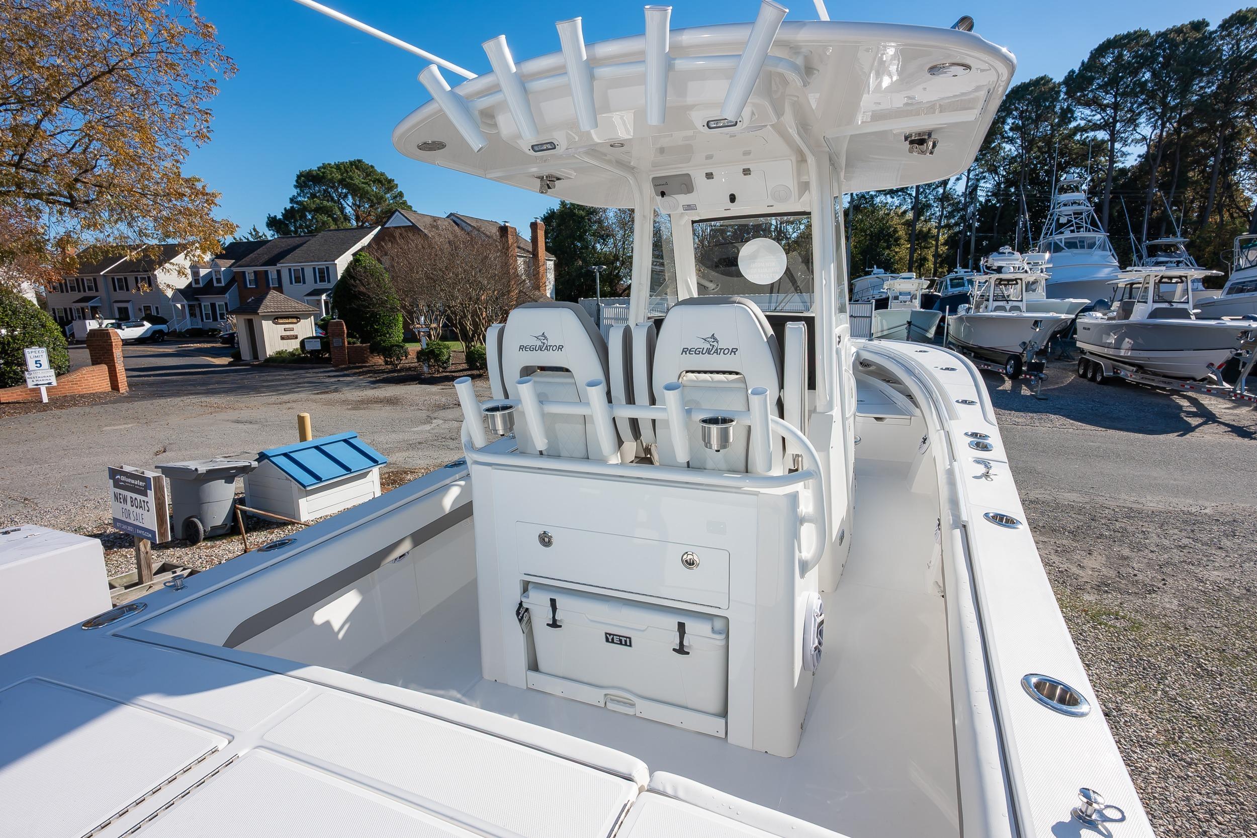 2026 Regulator 28 boat with center console and rod holders, docked in a marina.