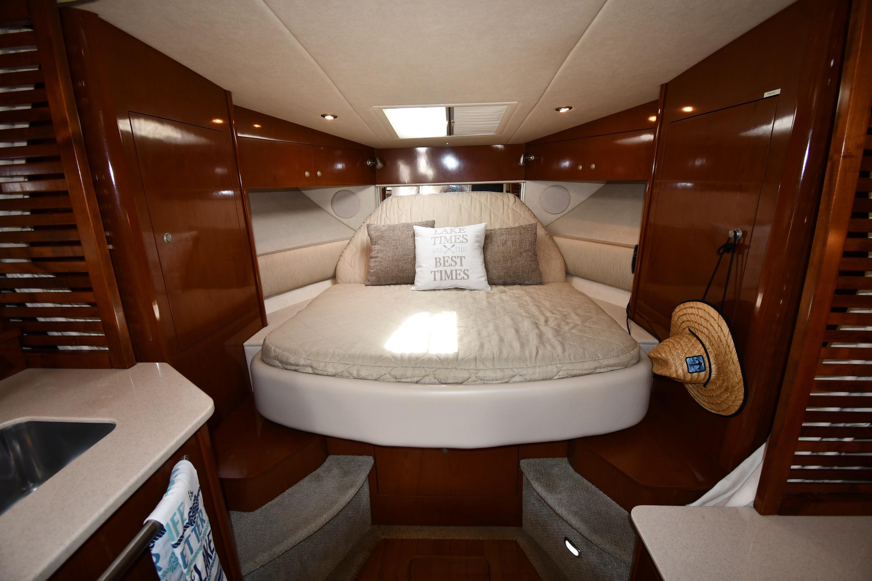 Luxurious cabin interior of 2008 Sea Ray Sundancer 350 yacht with cozy bed and wooden finish.