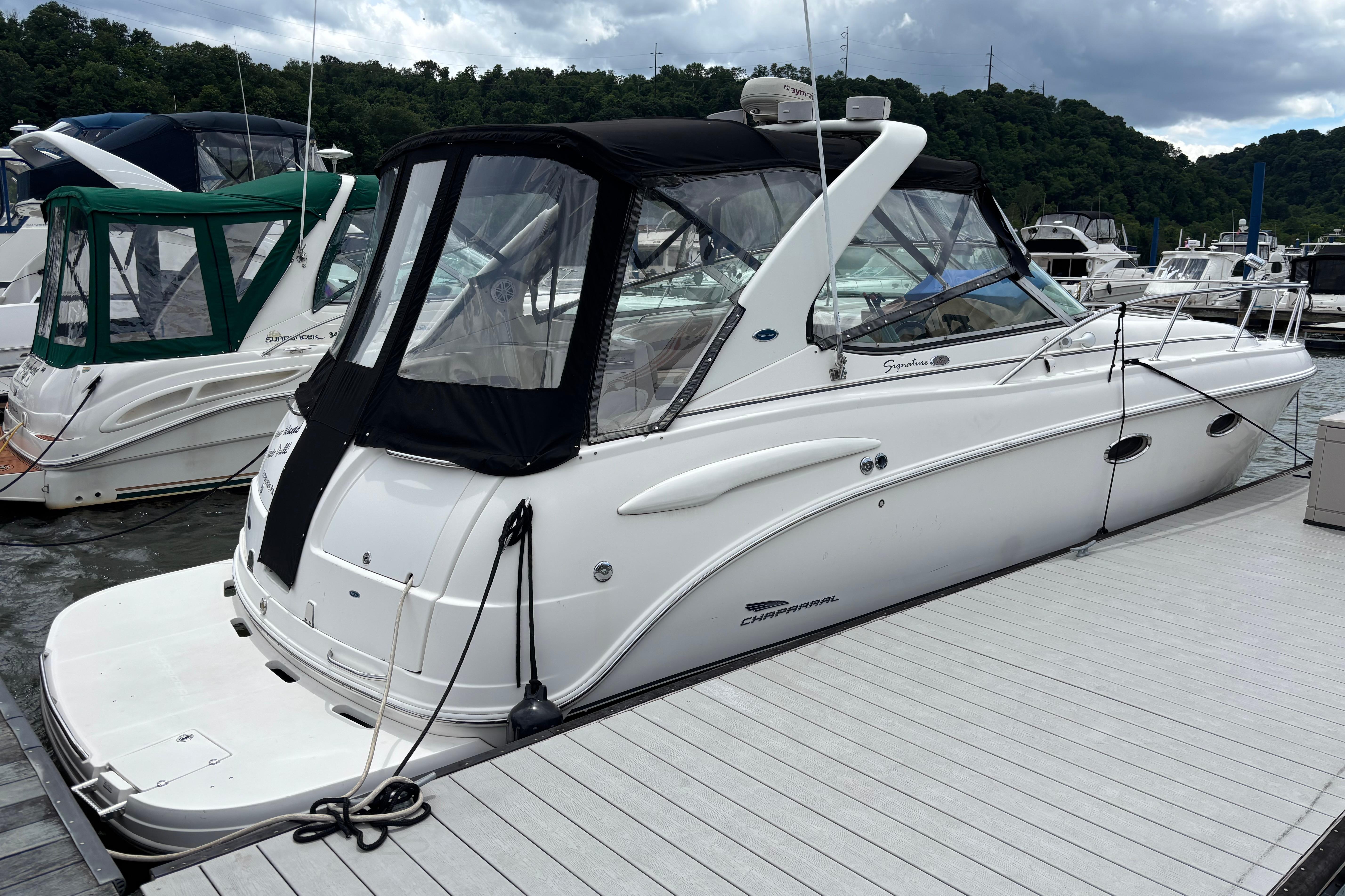 2004 Chaparral Signature 330 boat docked at marina, featuring sleek design and canopy.
