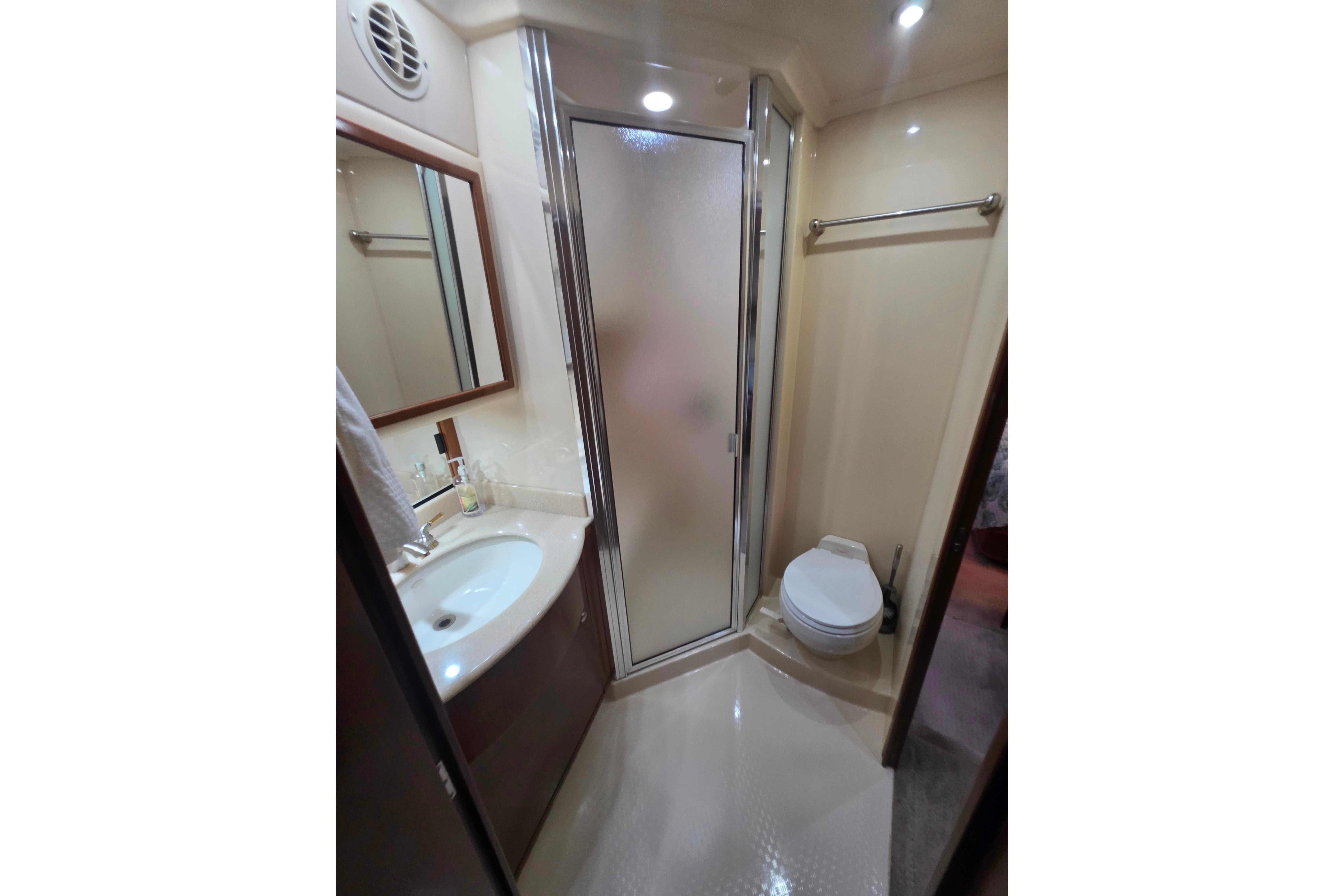 Luxurious bathroom in 2005 Meridian 580 Pilothouse yacht with shower, sink, and toilet.
