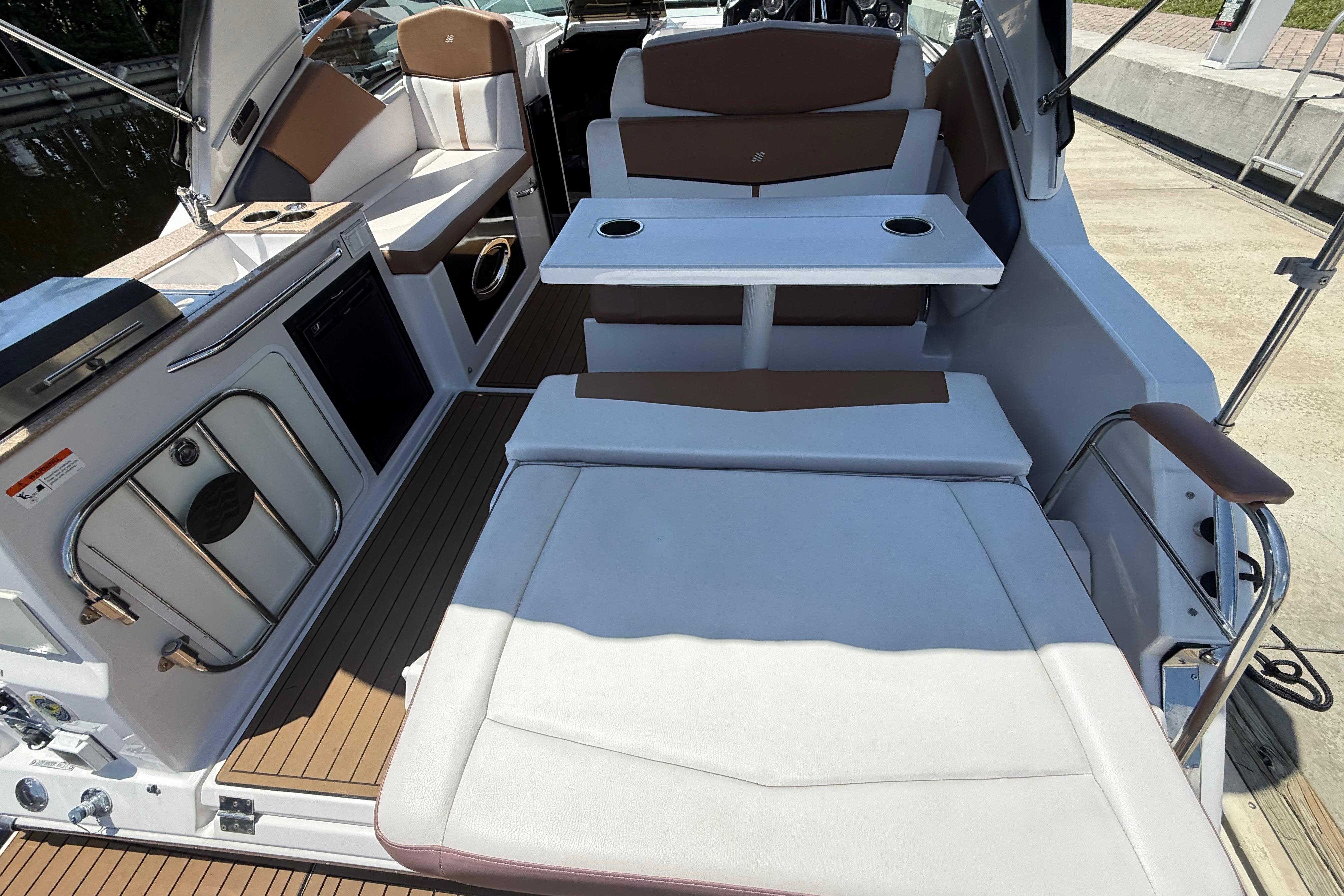 2017 Four Winns V275 boat interior with seating, table, and kitchenette.