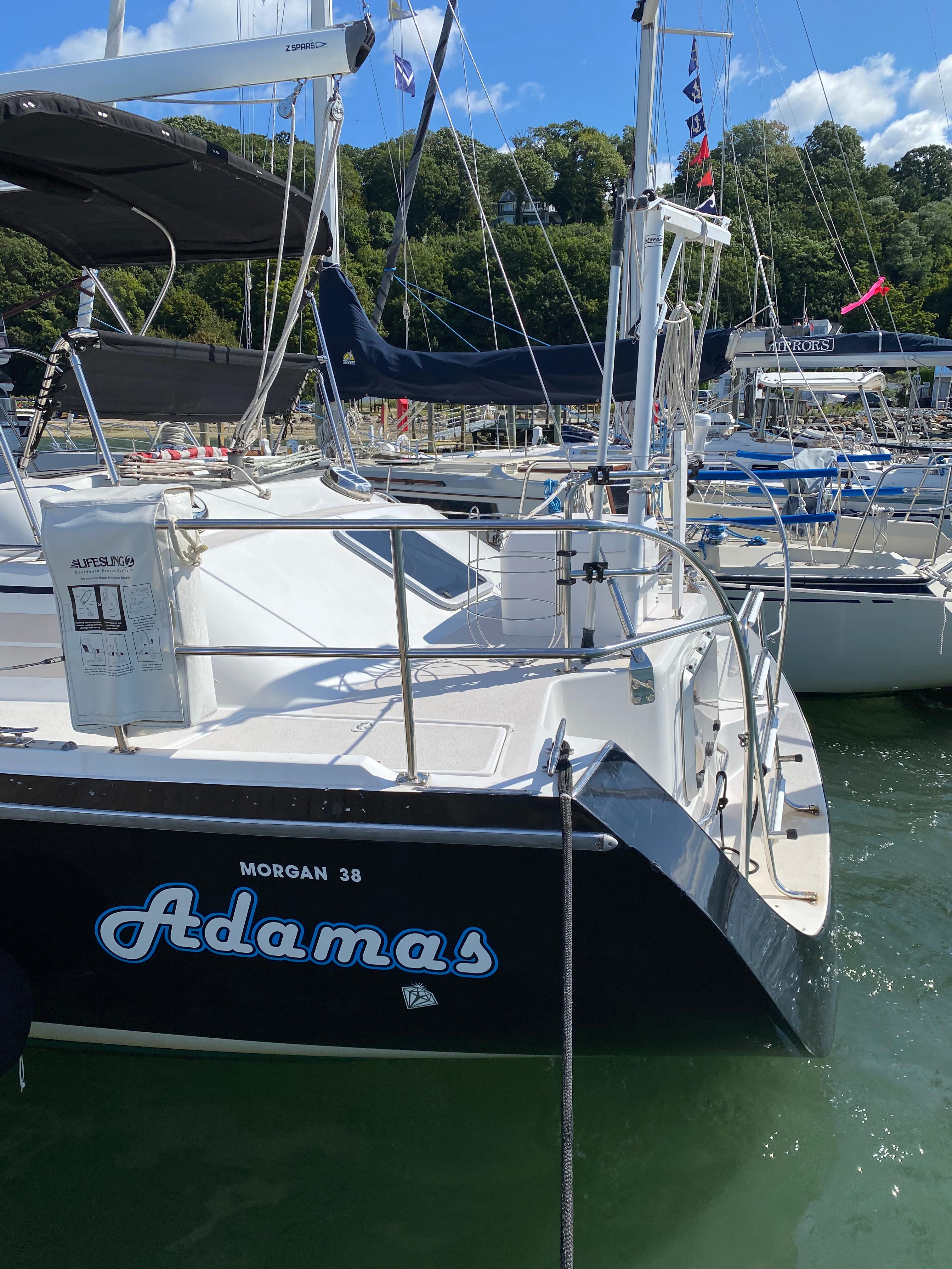 Sailboat "Adamas" docked, Catalina Morgan 38, 1997 model, in a sunny marina setting.