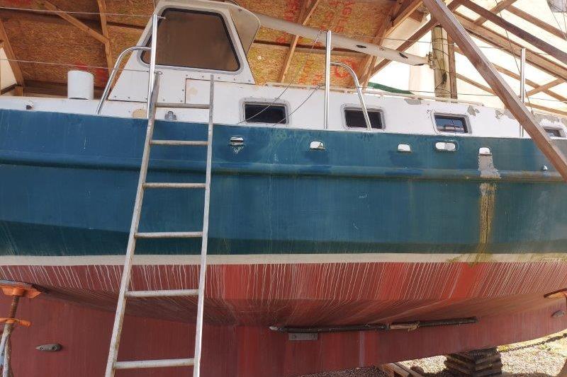 2017 Bruce Roberts Spray sailboat under maintenance in a covered dock.