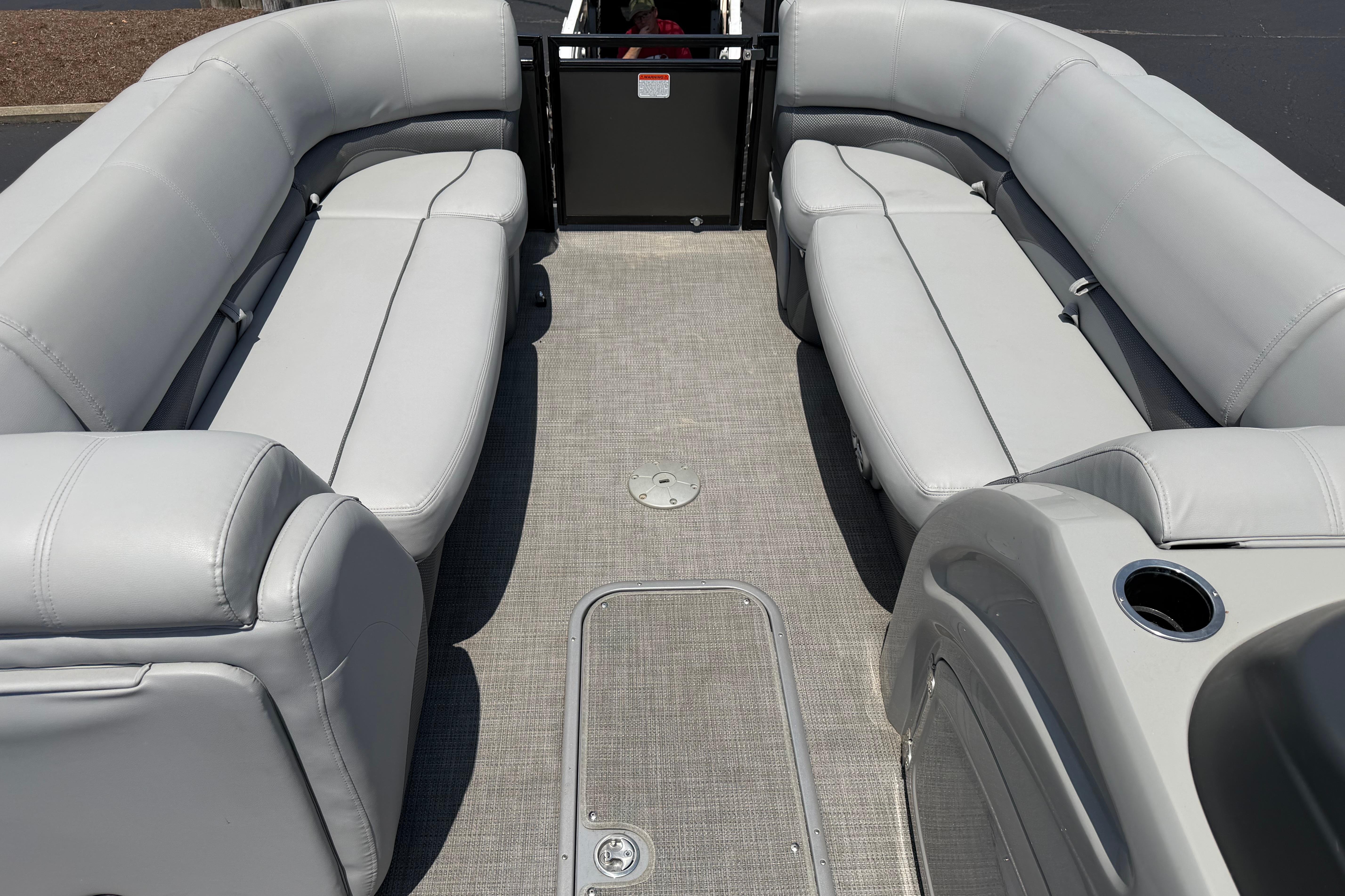 2019 Regency 230 DL3 pontoon boat interior with gray seating and carpeted flooring.