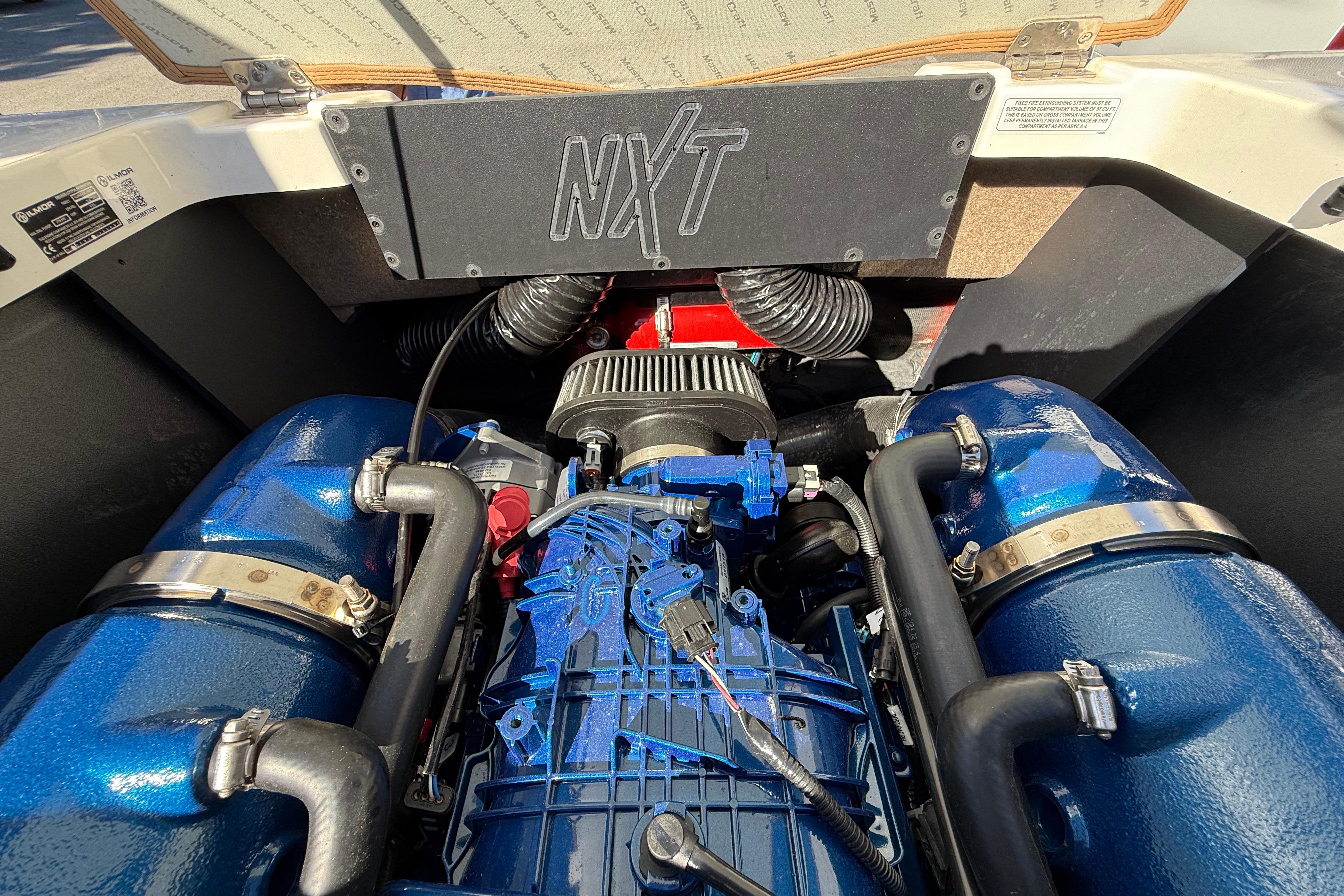 Engine compartment of 2022 MasterCraft NXT24 boat, showcasing detailed components and design.