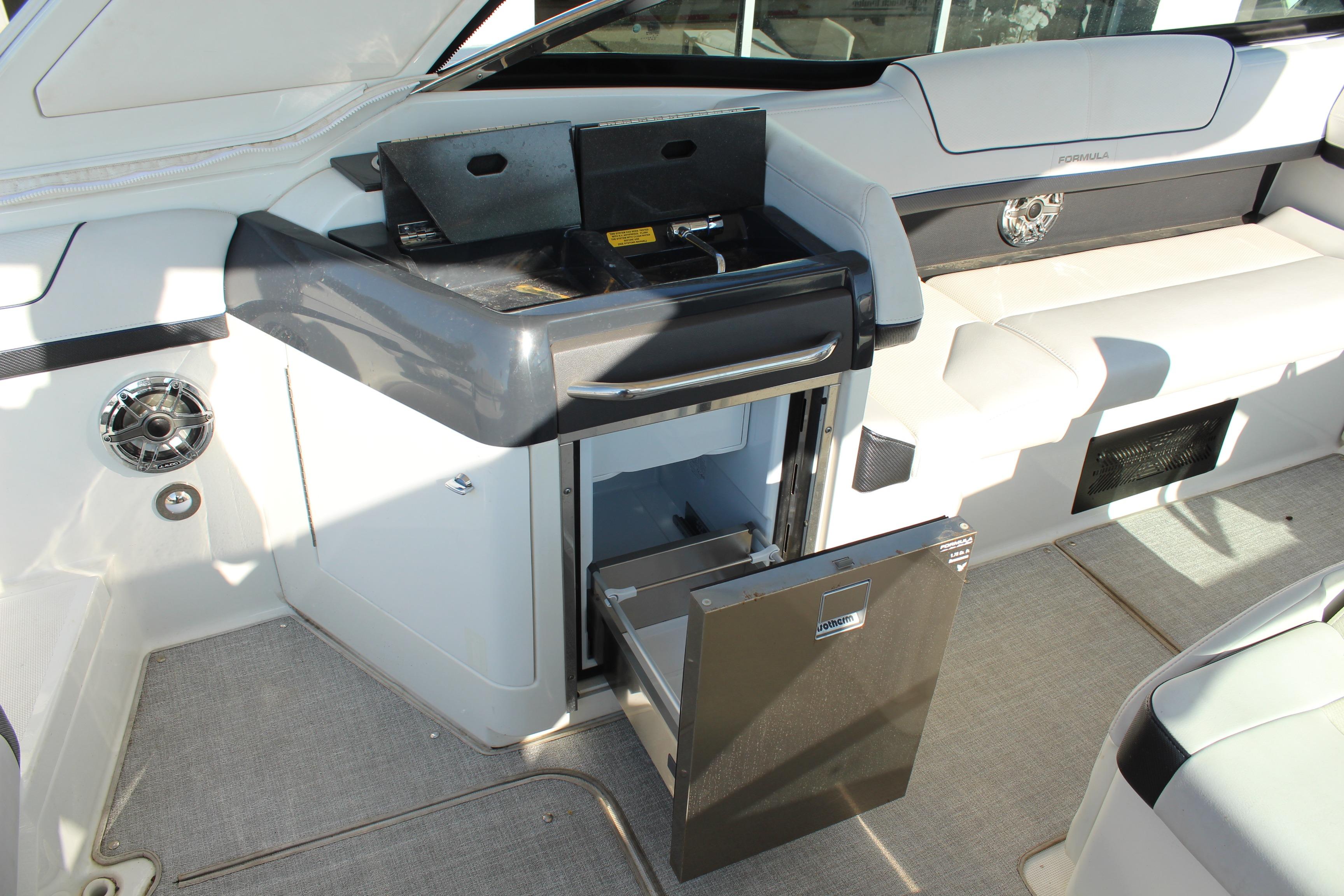 2023 Formula 310 Bowrider I/O interior with open mini fridge and sleek seating.