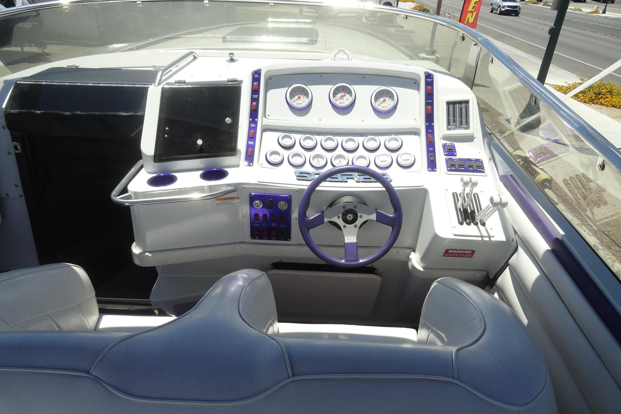 Cockpit of 1988 Wellcraft 34 Scarab boat with steering wheel and control panel.