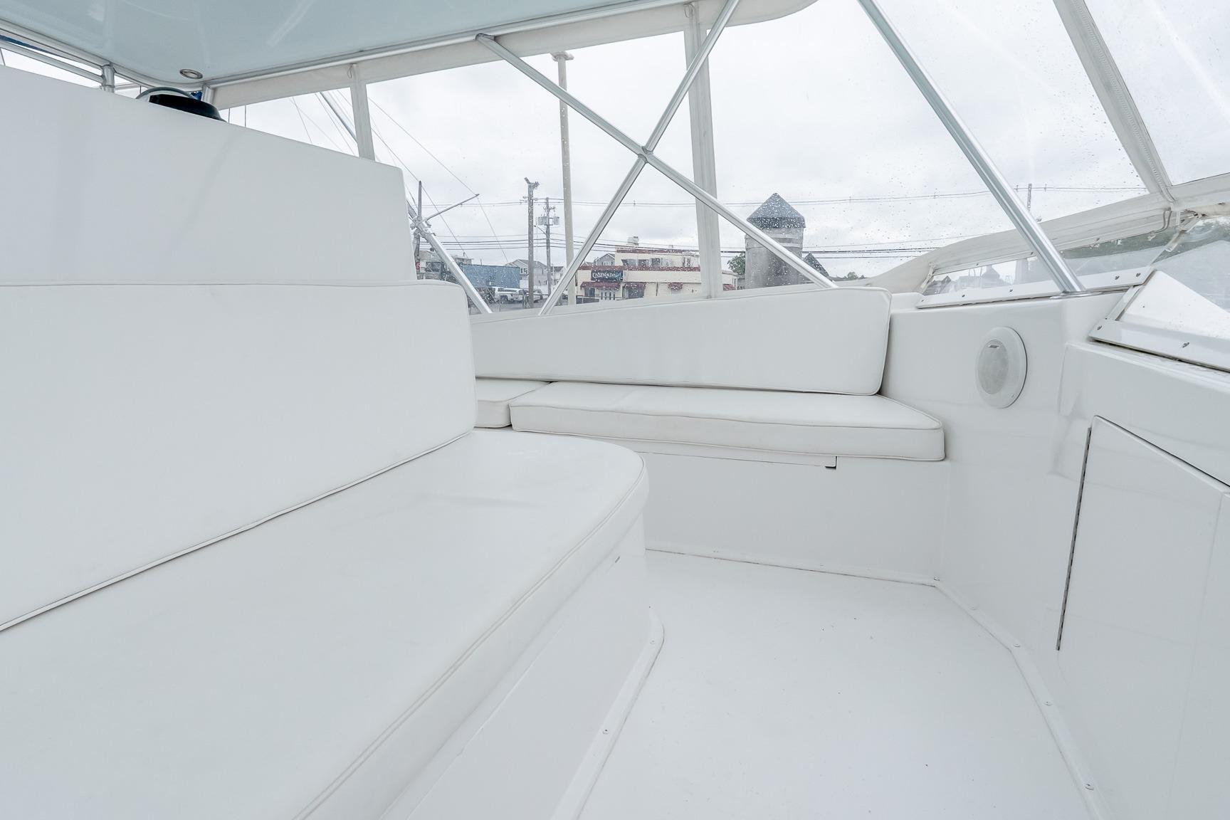 Interior of 2000 Viking 50' Convertible yacht with white seating and panoramic windows.