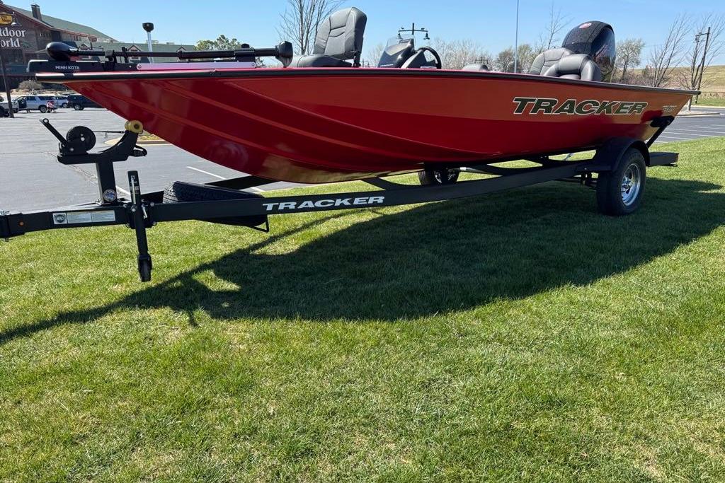 Red 2026 Tracker Pro Team 195 boat on trailer, parked on grass.