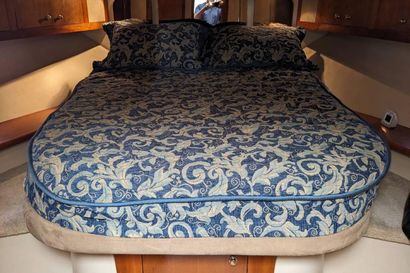 Luxurious bed in 2003 Cruisers 3970 yacht cabin with elegant floral bedding.