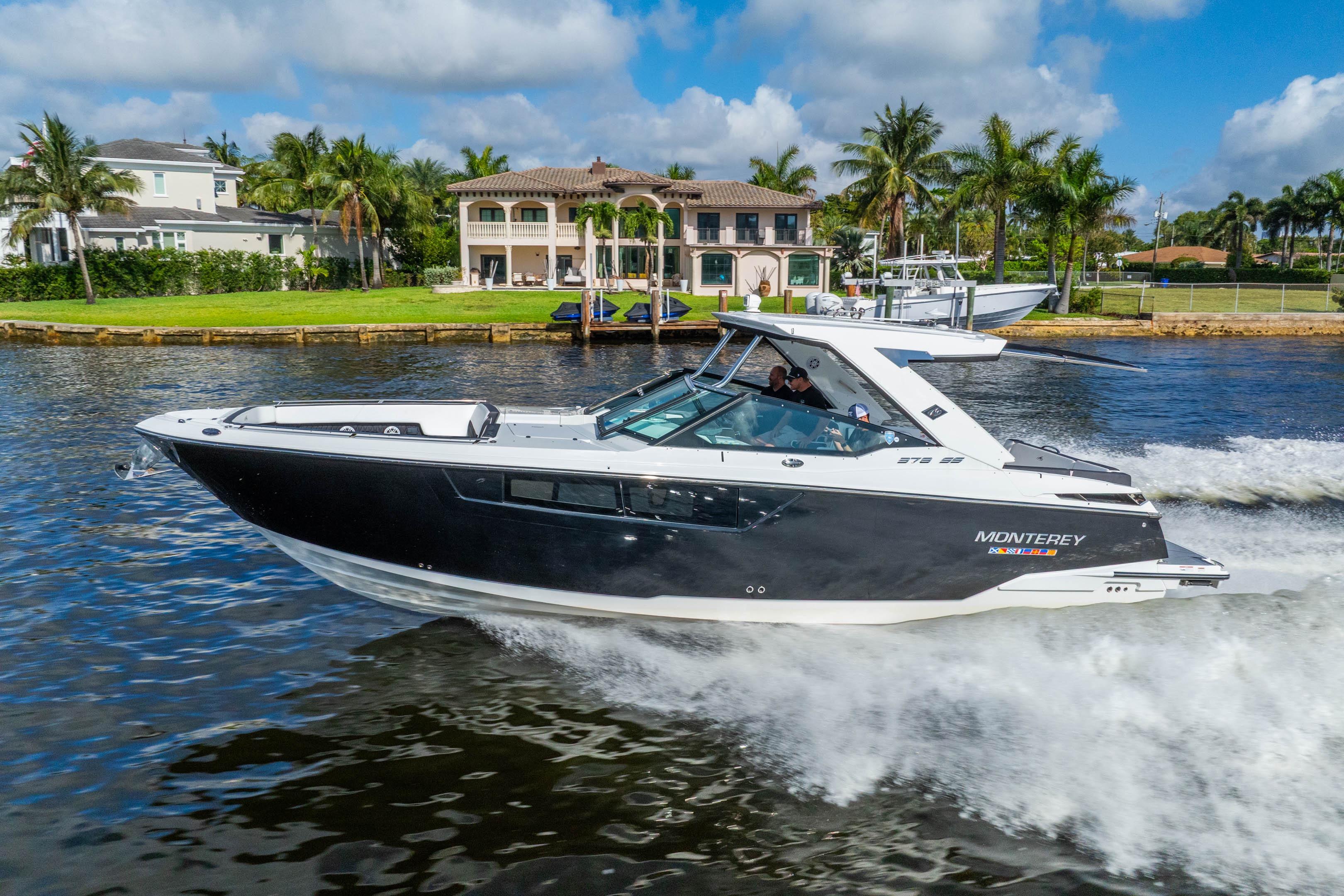 2022 Monterey 378SS Super Sport boat cruising on a sunny day near waterfront homes.