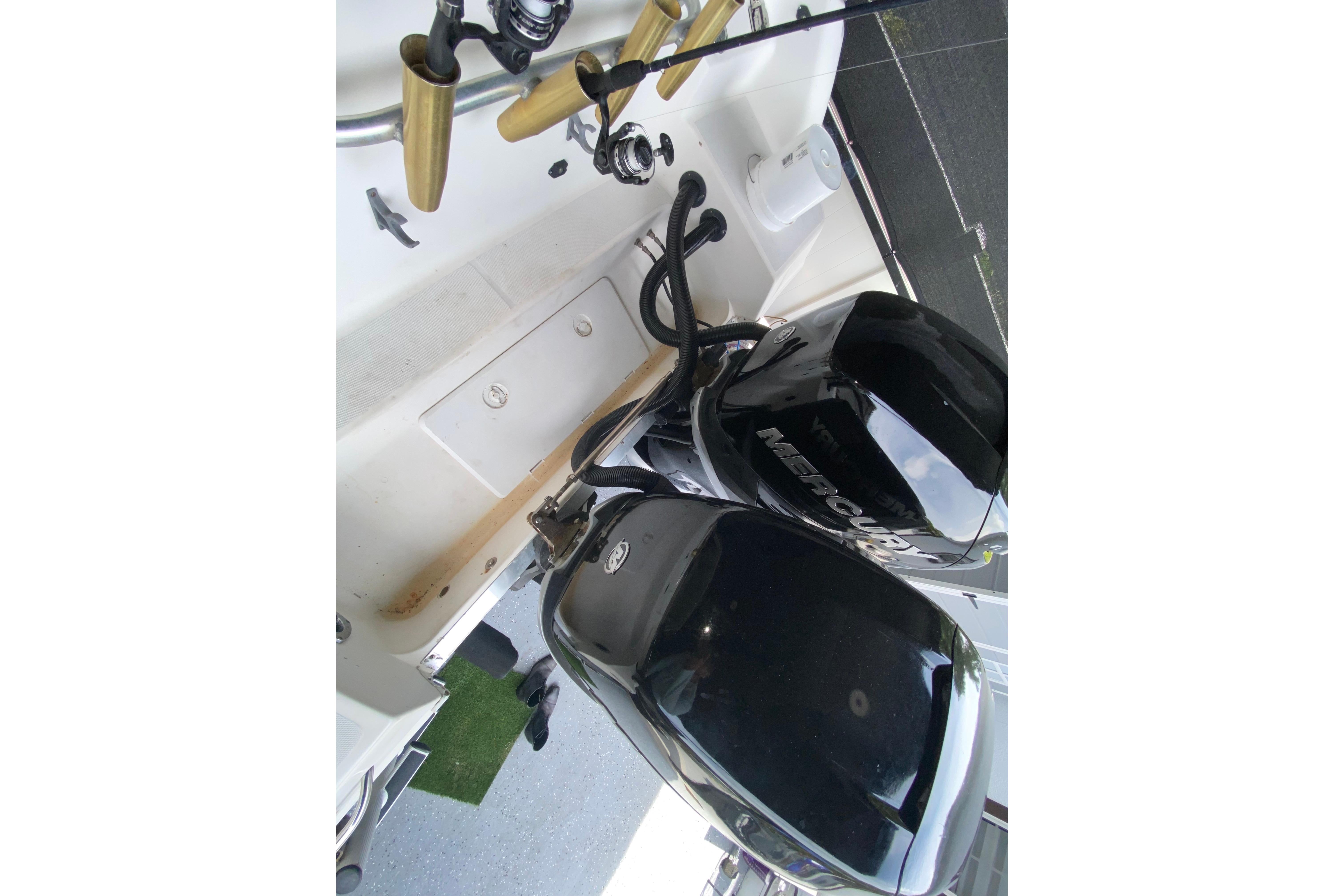 2005 Wellcraft 290 Coastal boat with dual Mercury outboard engines and fishing rods.