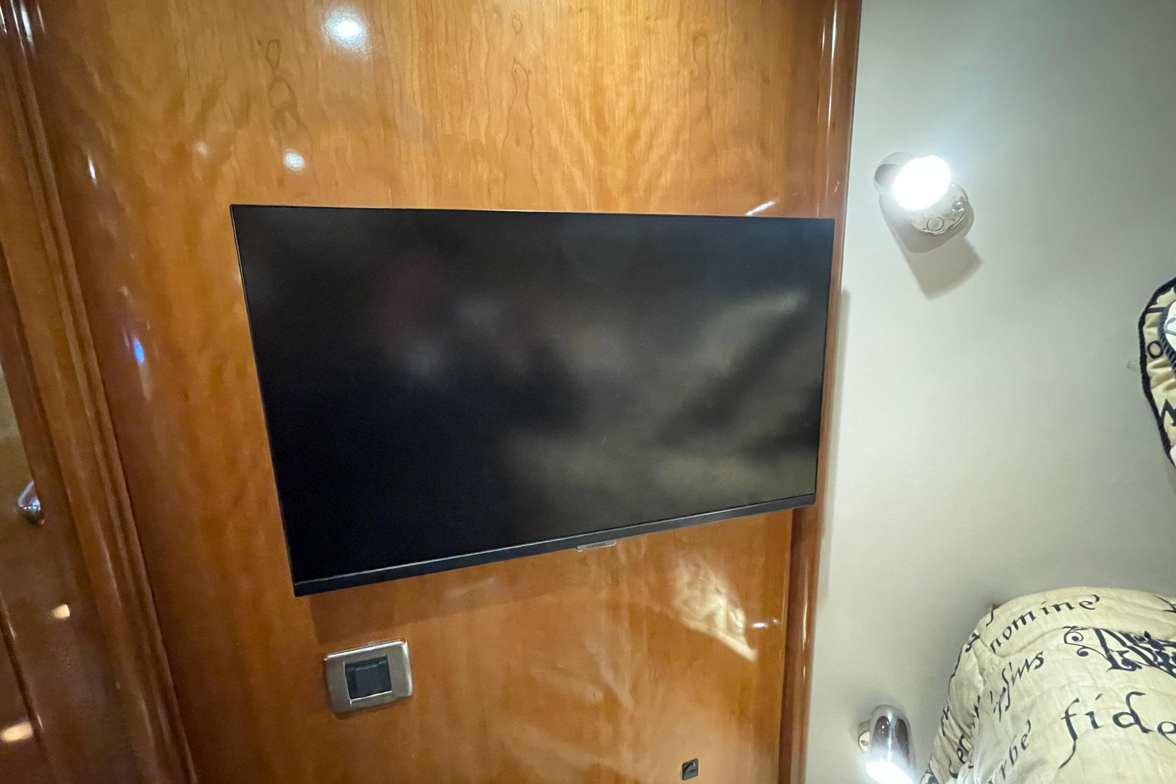 Flat-screen TV mounted on wooden wall inside 2002 Carver 570 Voyager Pilothouse yacht.