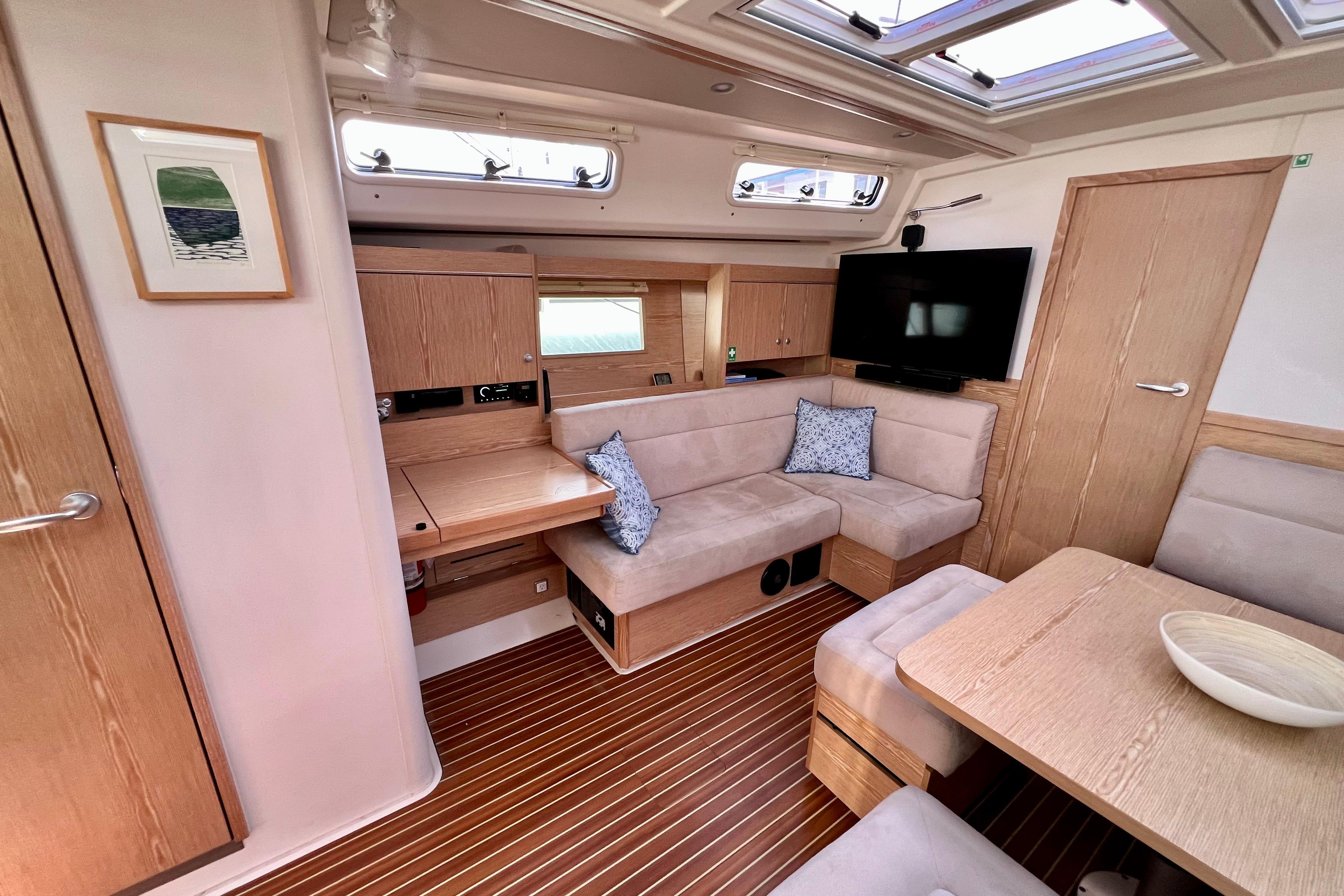 Luxurious interior of 2016 Hanse 455 yacht with modern seating and wooden finishes.