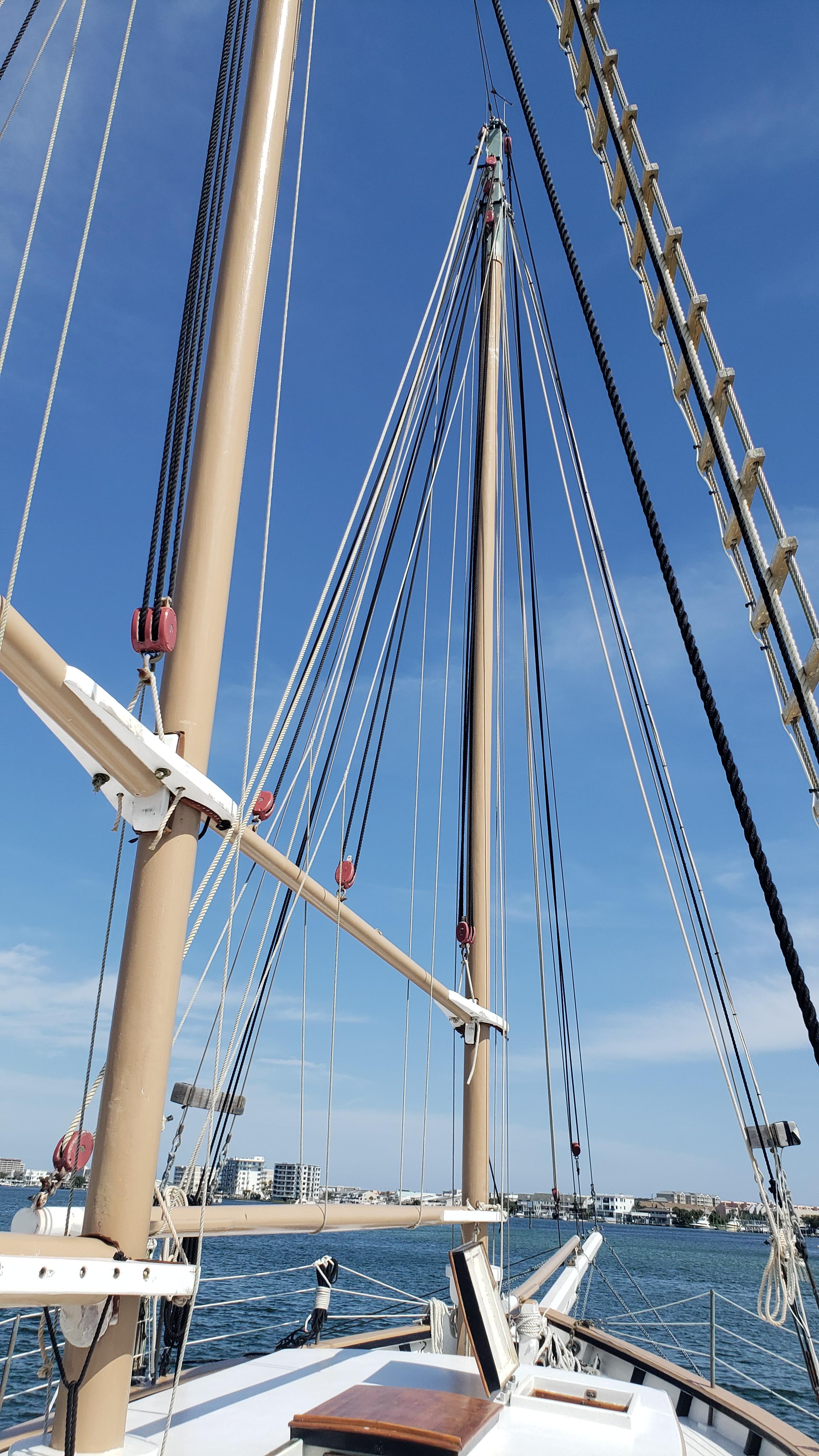 Alt text: 1996 Custom Biloxi Schooner mast and rigging against blue sky.