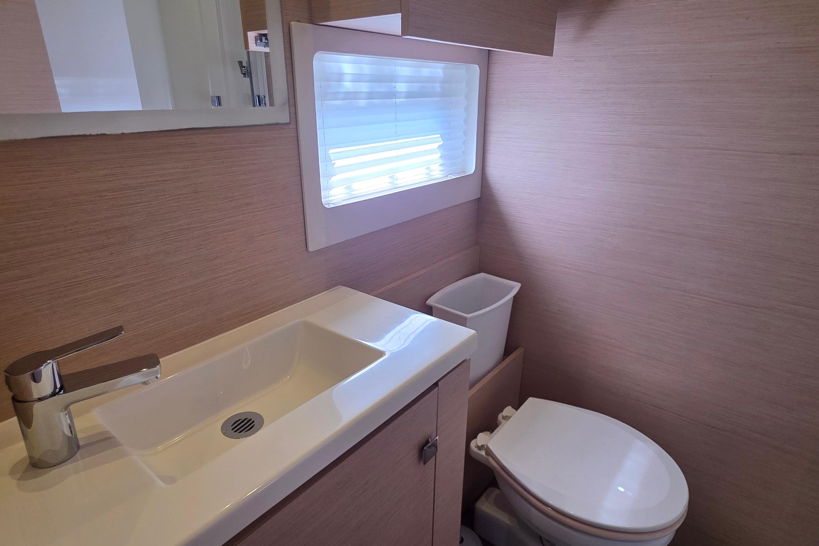 Modern bathroom in 2018 Fountaine Pajot Motor Yacht 44, featuring sleek sink and toilet.