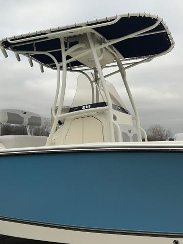 2024 Mako 214 CC center console boat with blue hull and T-top.