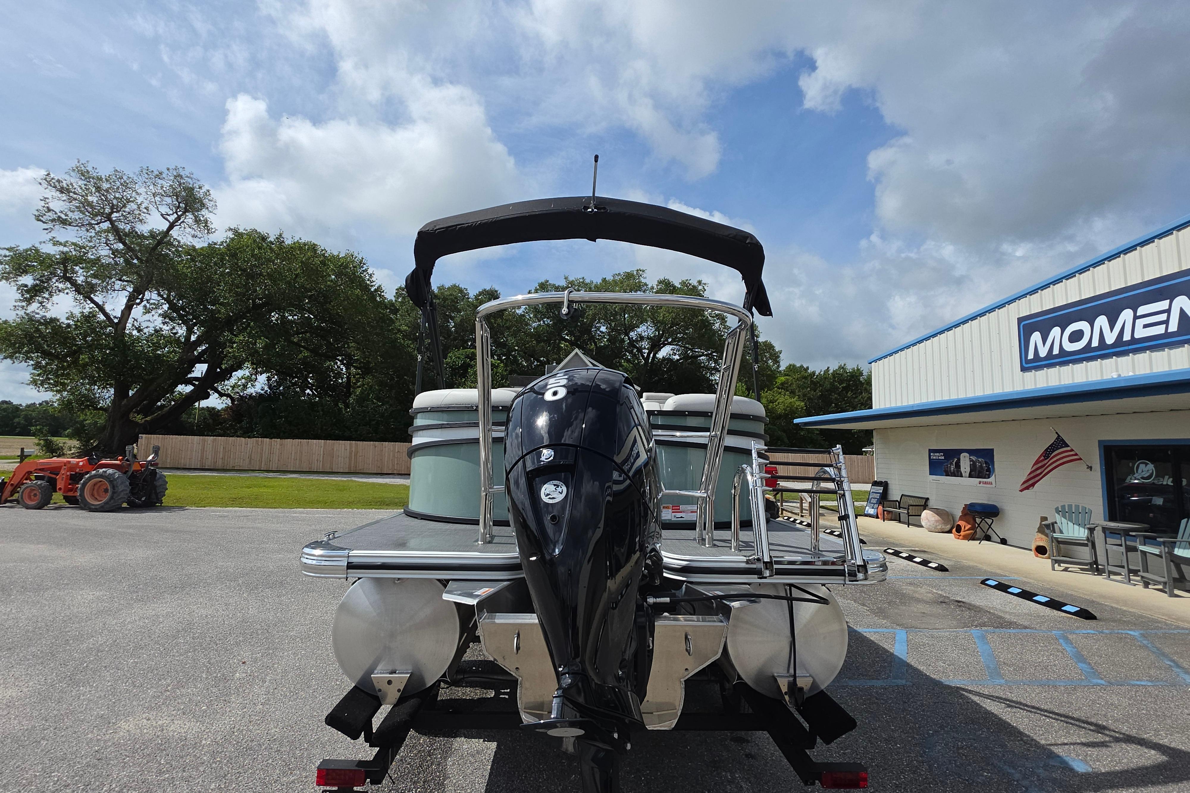 2026 Crest 235 Conquest SLC pontoon boat with outboard motor, parked near dealership.