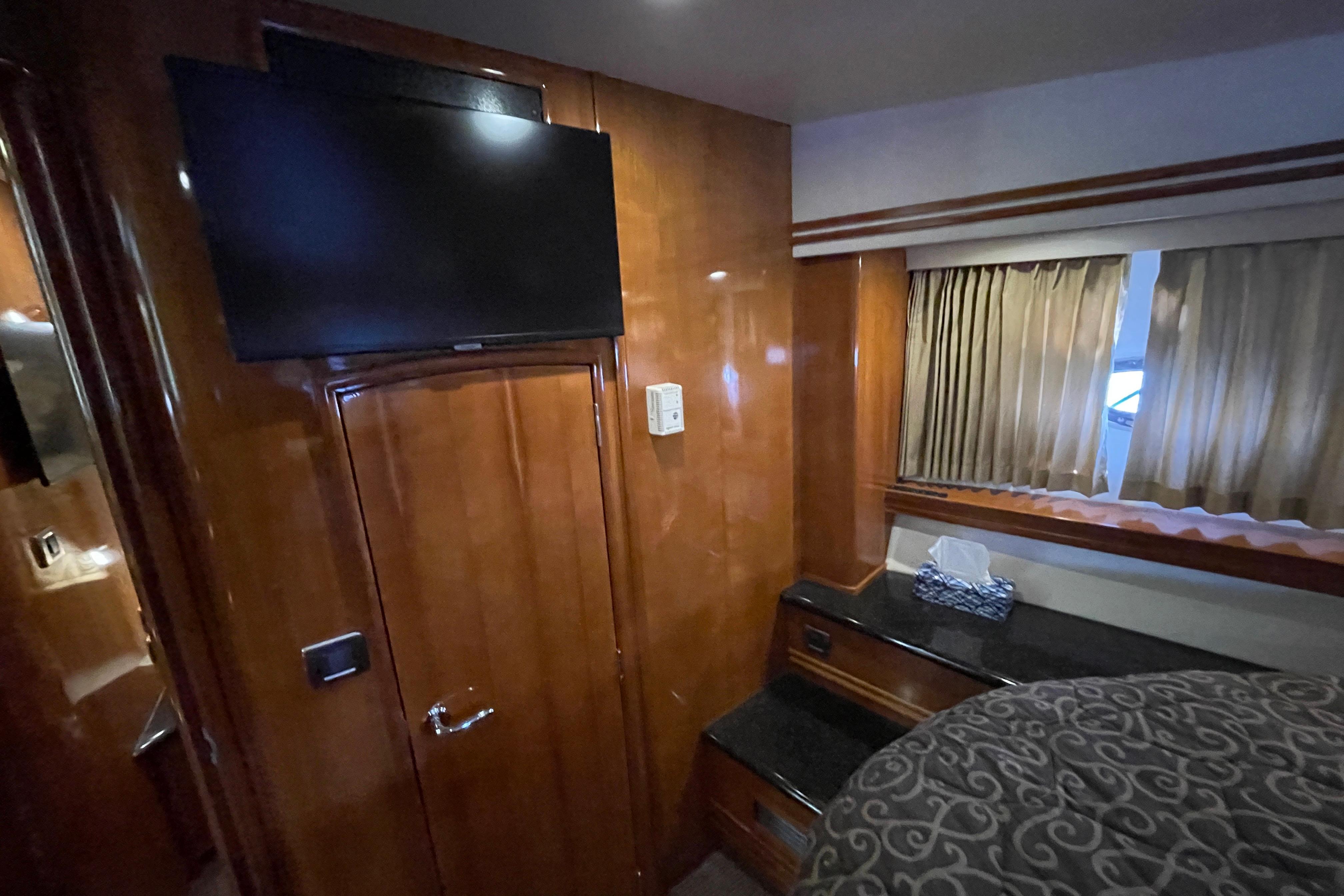 Interior of 2002 Carver 570 Voyager Pilothouse with TV, wood paneling, and window curtains.