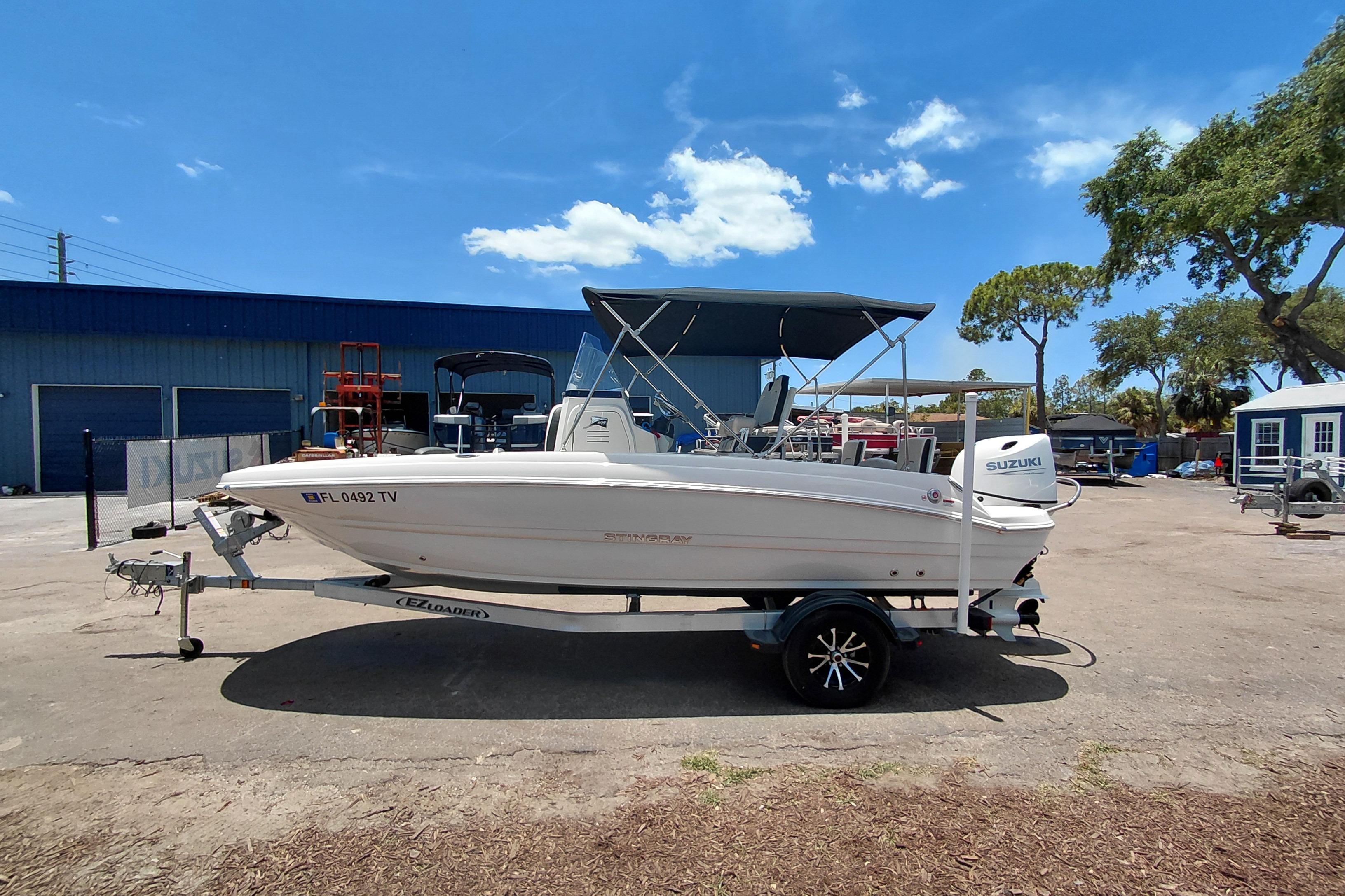 2023 Stingray 206 CC boat on trailer, parked outdoors under a clear blue sky.