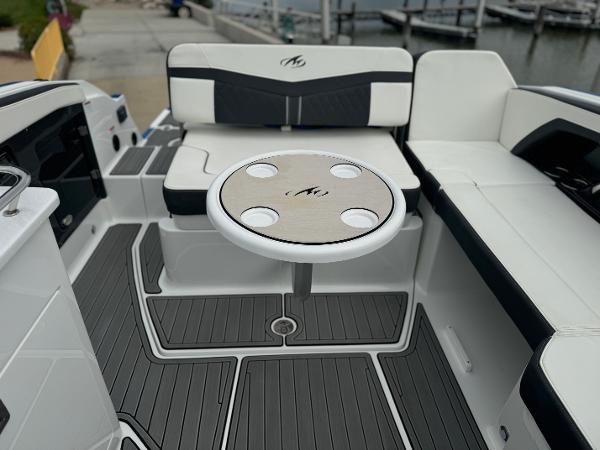2018 Monterey 258 Super Sport boat interior with seating and table, dockside view.