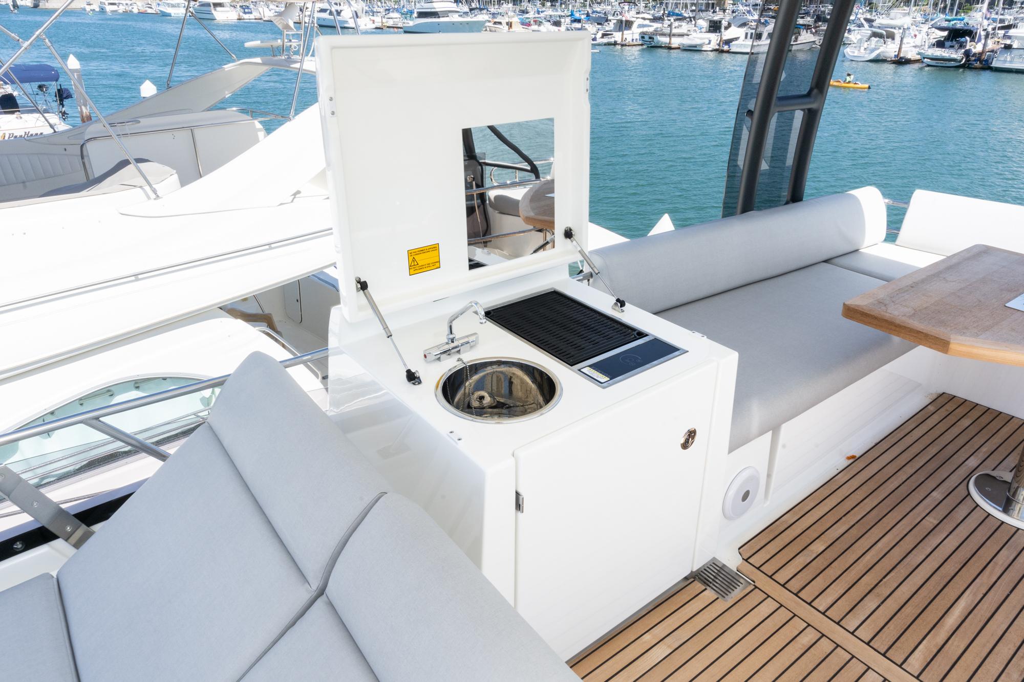 Prestige 460 yacht 2022 model with outdoor sink and seating area, docked at marina.