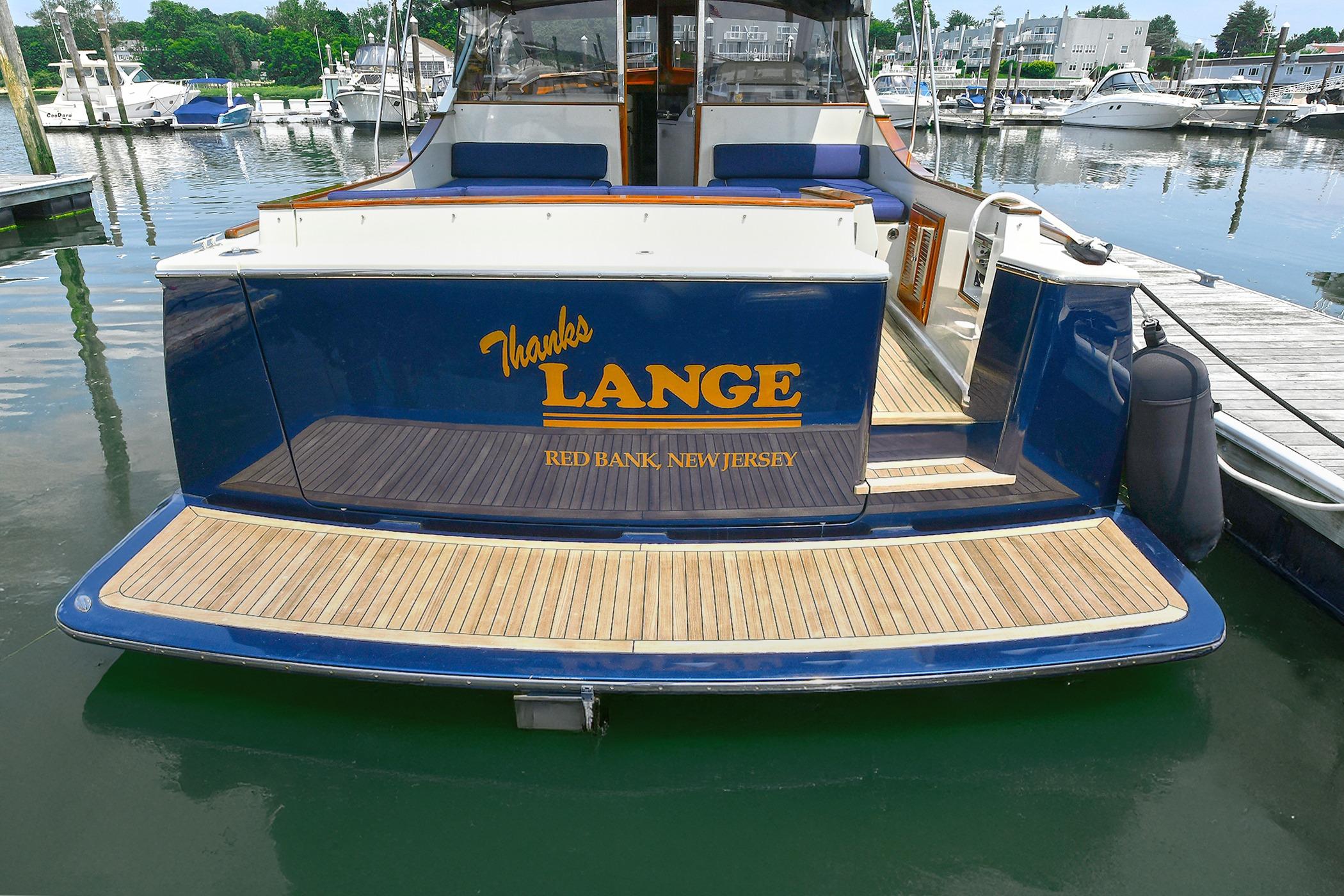 2005 San Juan Downeast Express boat docked, featuring teak deck and "Thanks Lange" lettering.