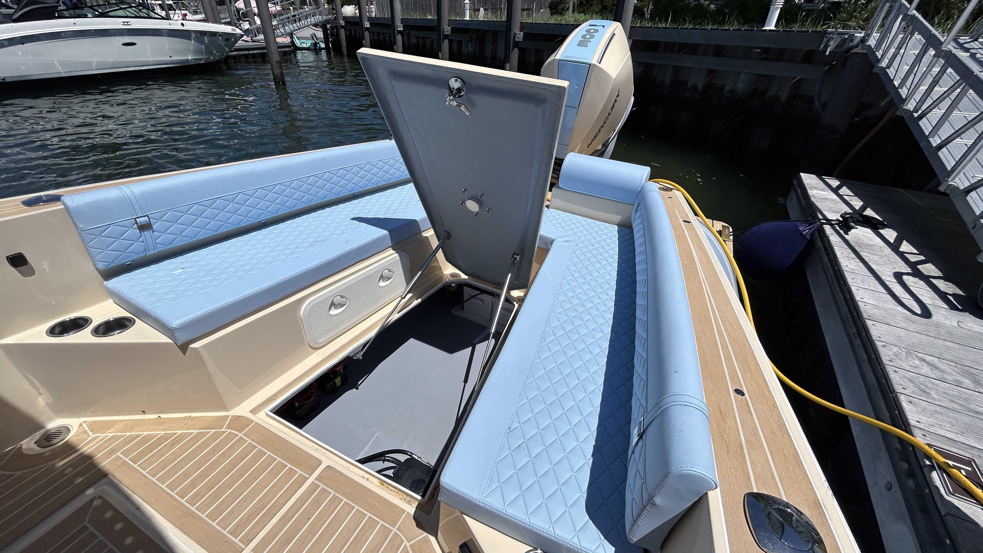 2025 Lilybaeum Levenzo boat interior with blue seating and open storage compartment.