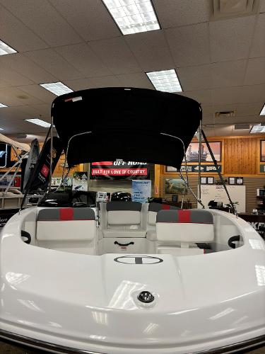2023 Tahoe T16 boat on display in showroom with canopy and seating.