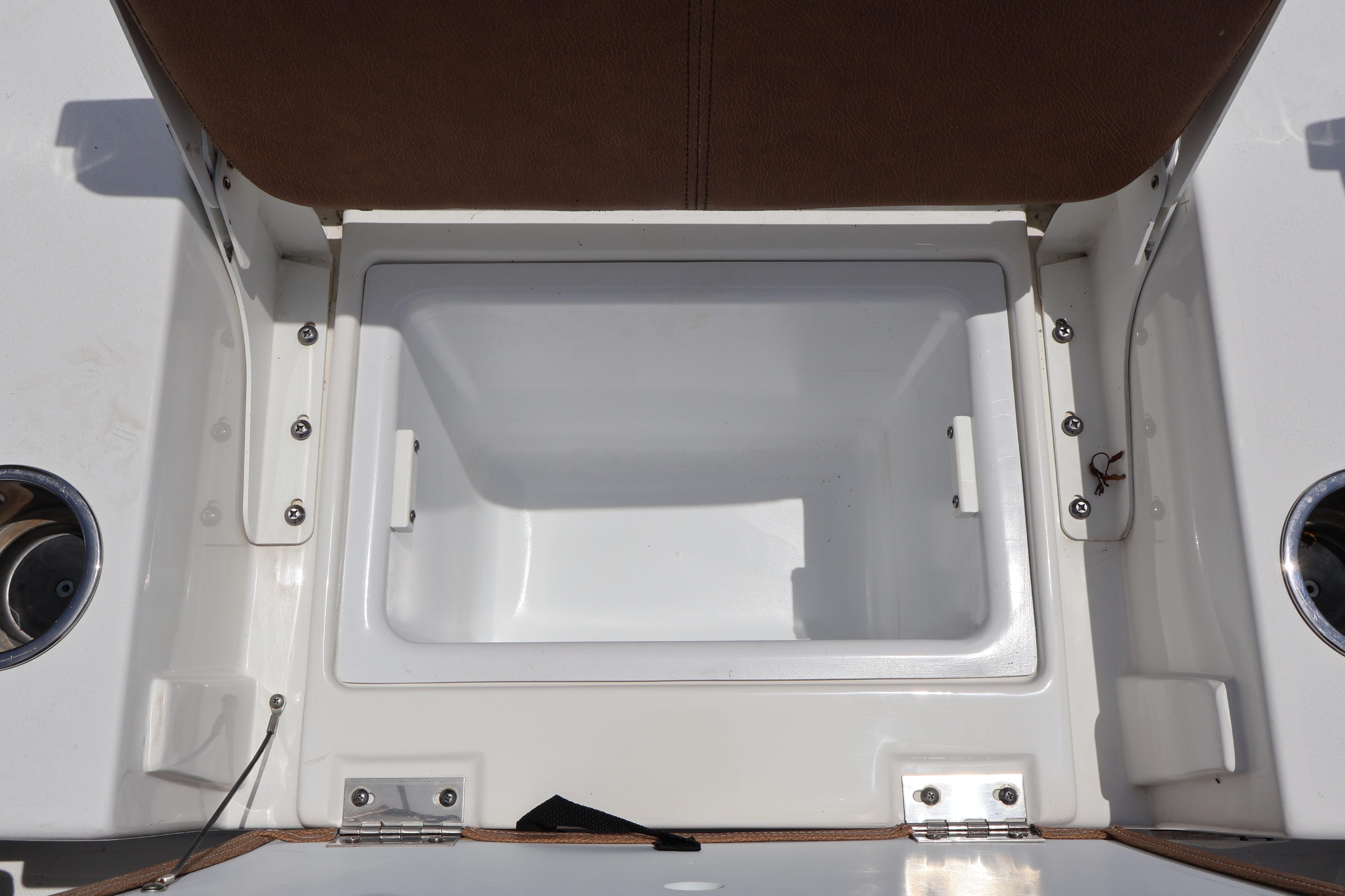 Open storage compartment on 2022 Sea Hunt BX 25 FS boat, featuring white interior and brown seating.