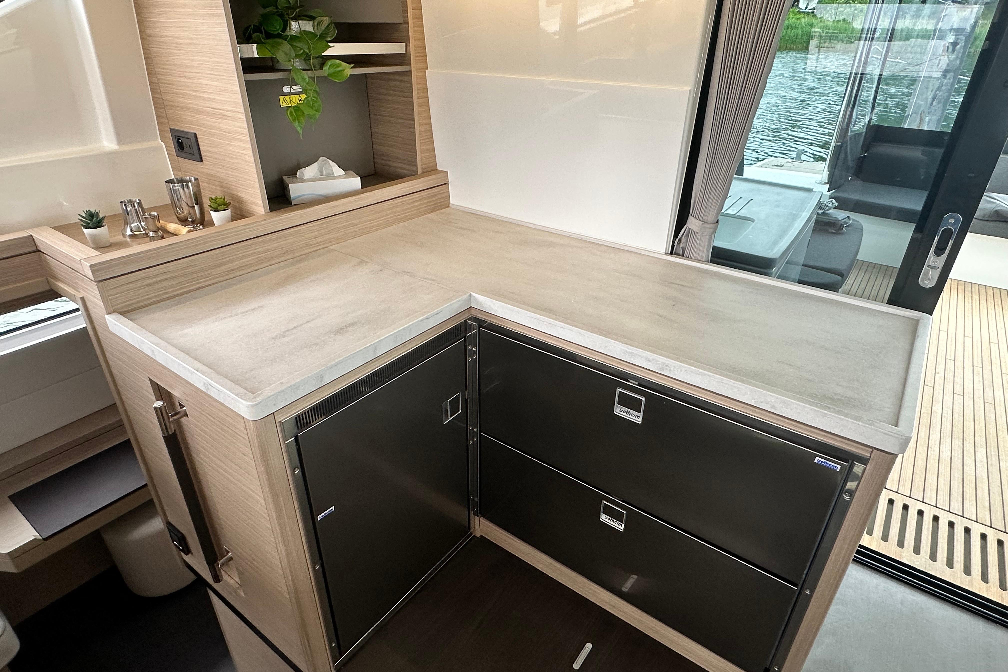 Modern kitchen area in 2026 Lagoon 51 yacht with sleek cabinetry and countertop.