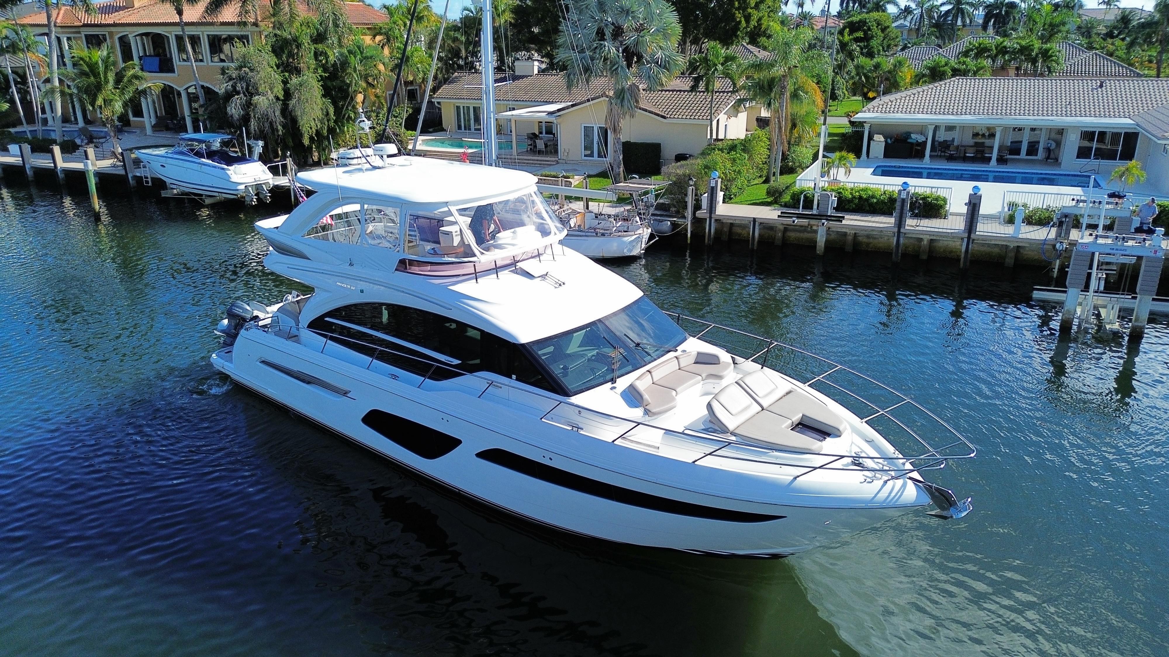 Luxurious 2019 Princess F62 yacht cruising near waterfront homes.