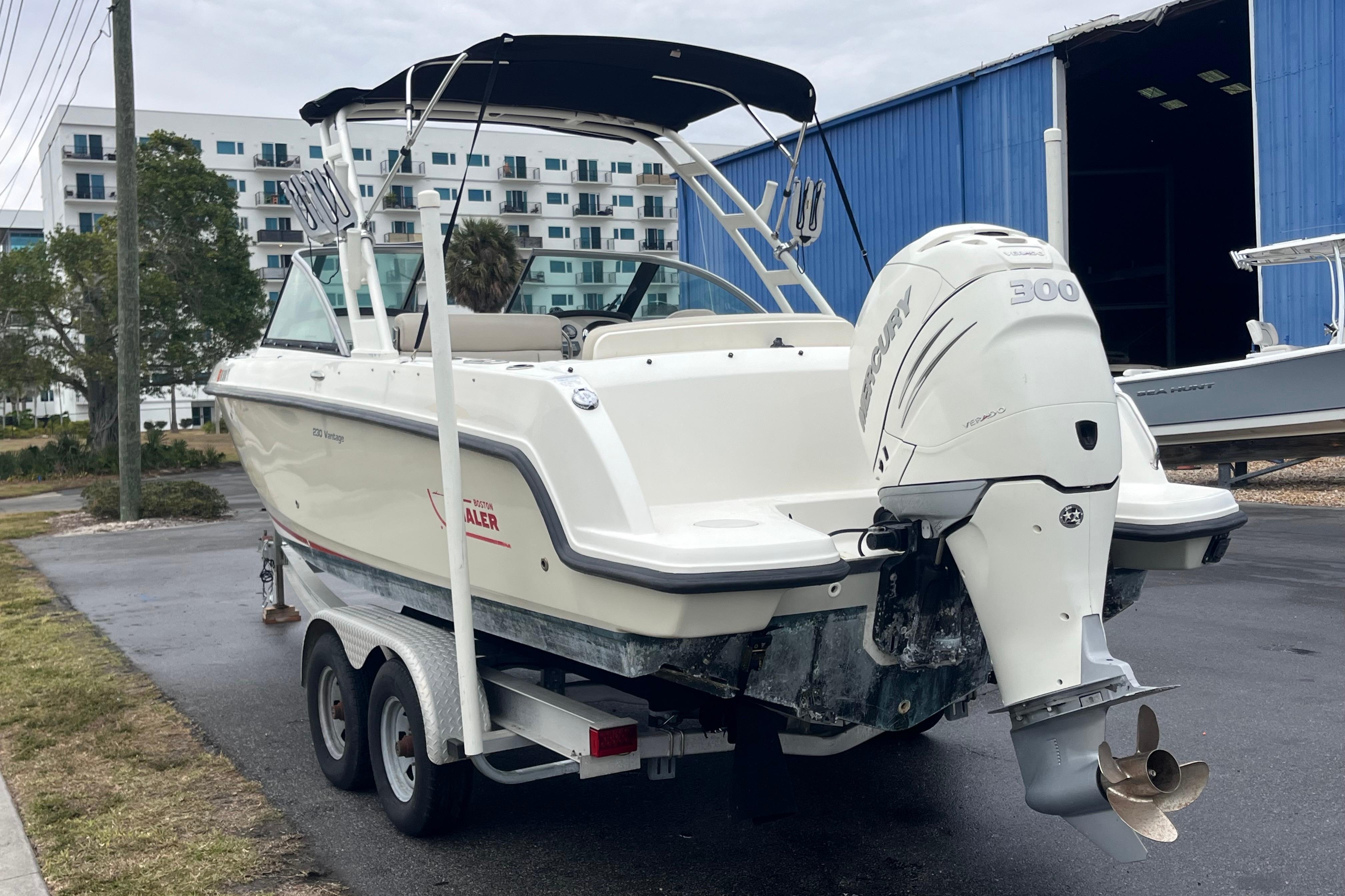 2015 Boston Whaler 230 Vantage boat on trailer with Mercury engine, parked outdoors.