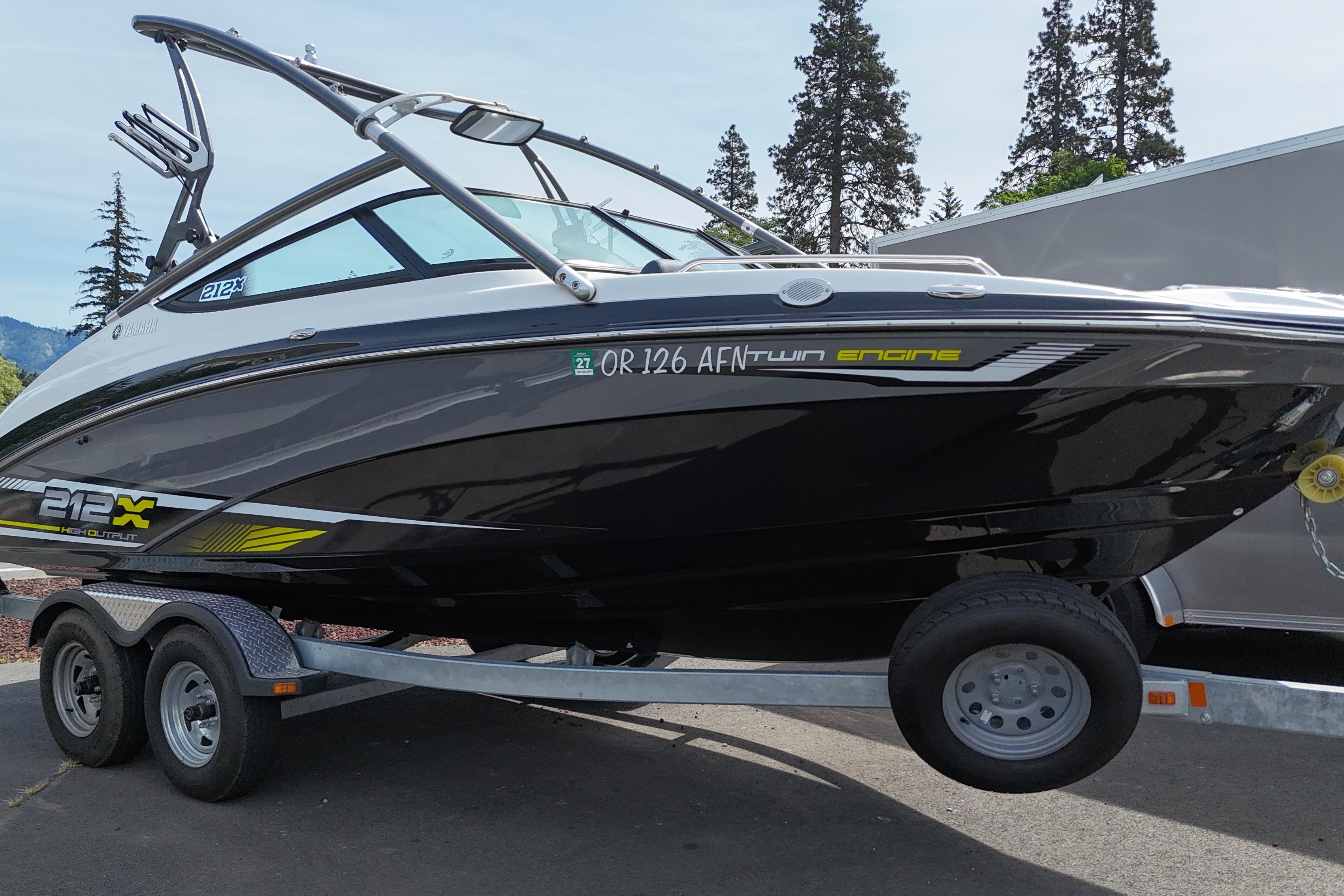 2016 Yamaha Boats 212X on trailer, sleek black design, parked outdoors.