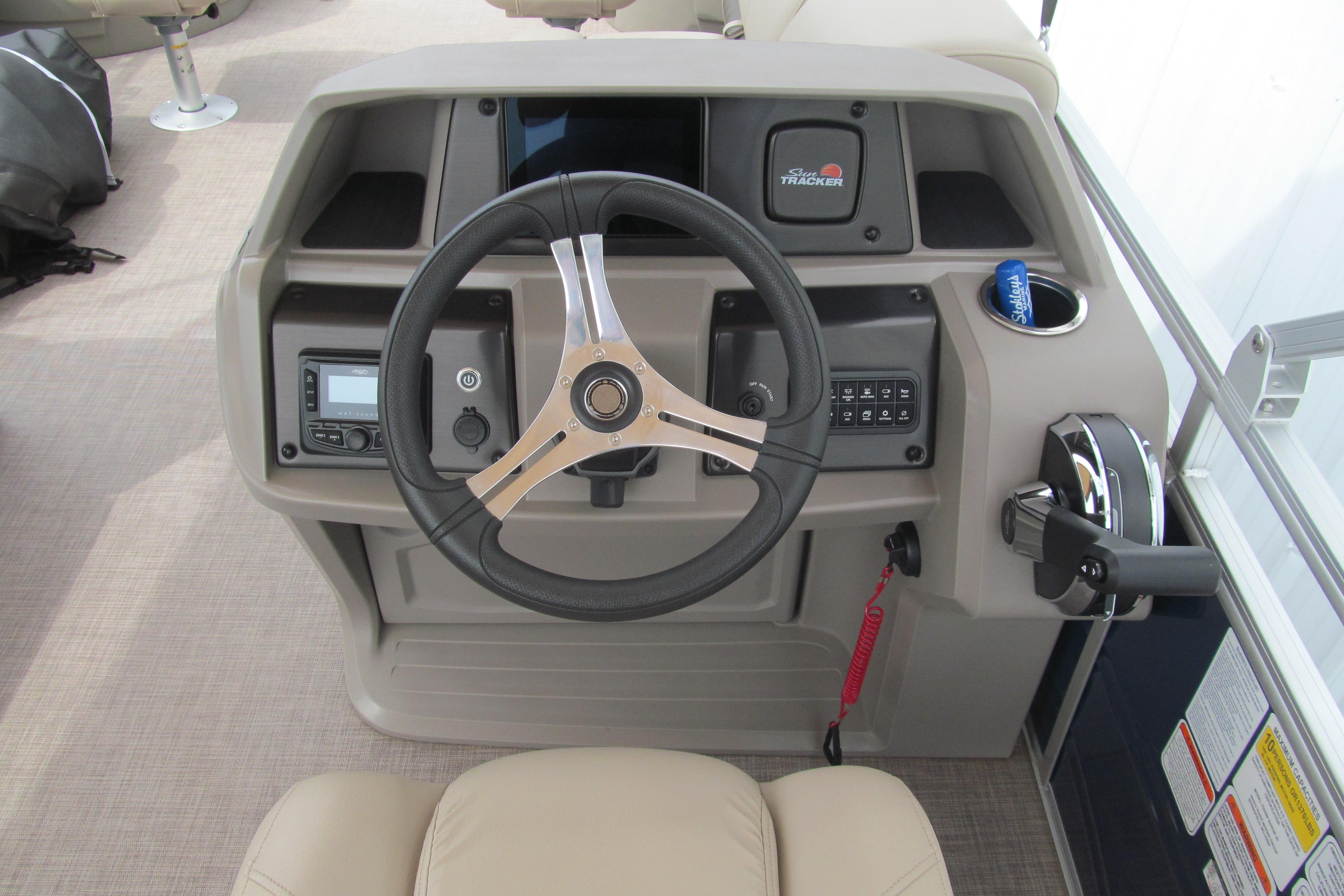 2024 Sun Tracker Fishin' Barge 20 DLX helm with steering wheel and control panel.