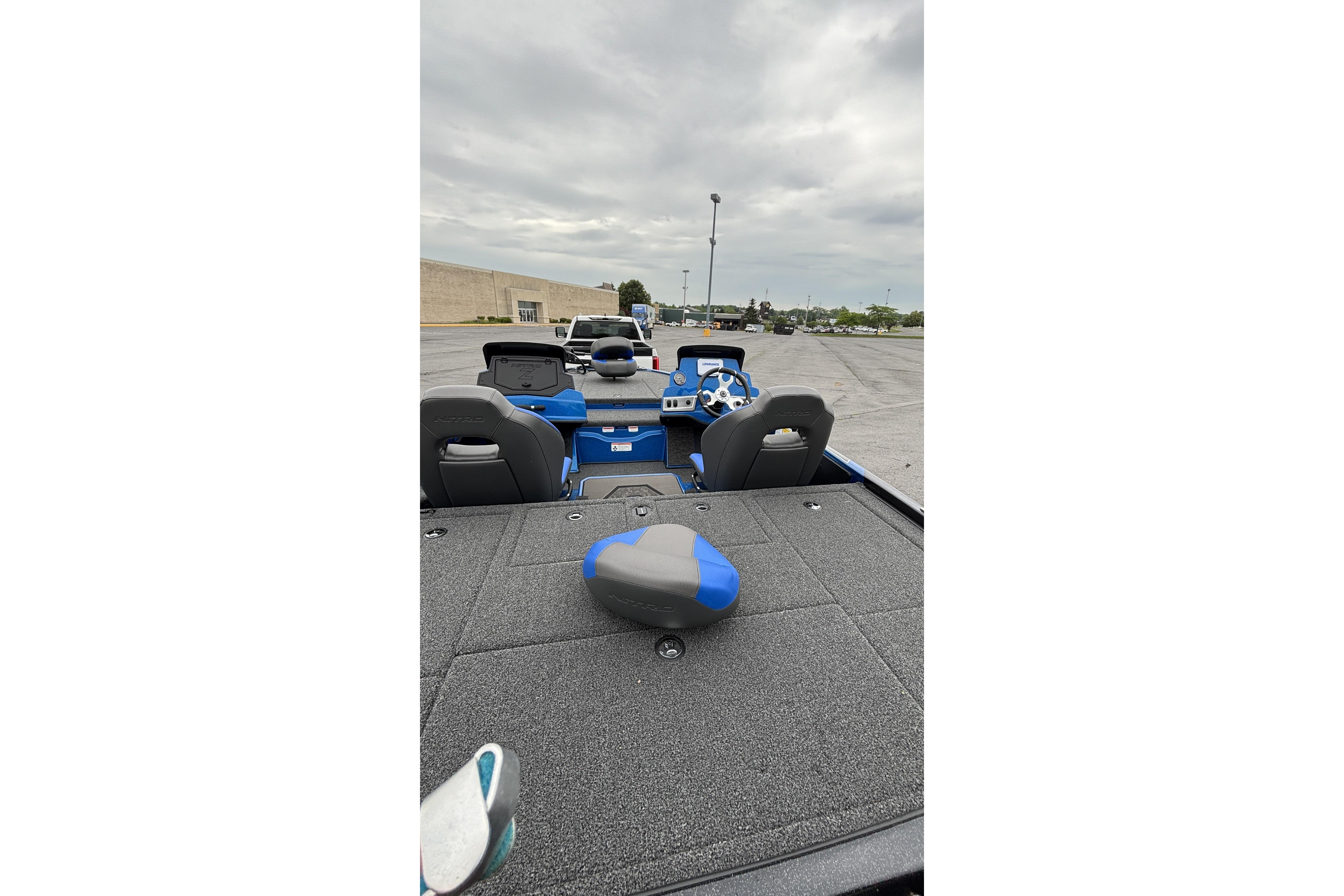 2026 Nitro Z19 XL boat interior with blue accents, parked outdoors under cloudy skies.
