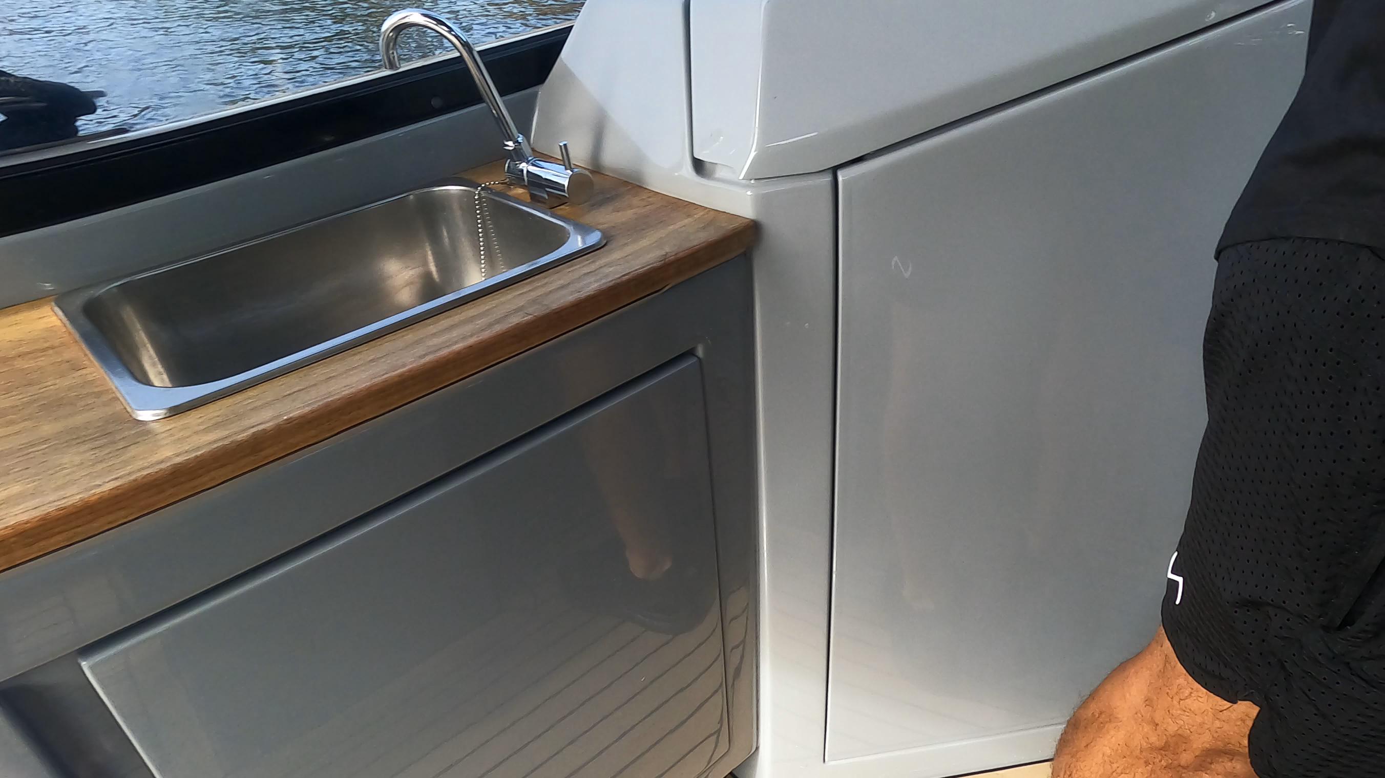 Modern boat kitchen with stainless steel sink and wooden countertop, Rand Leisure 2021 model.