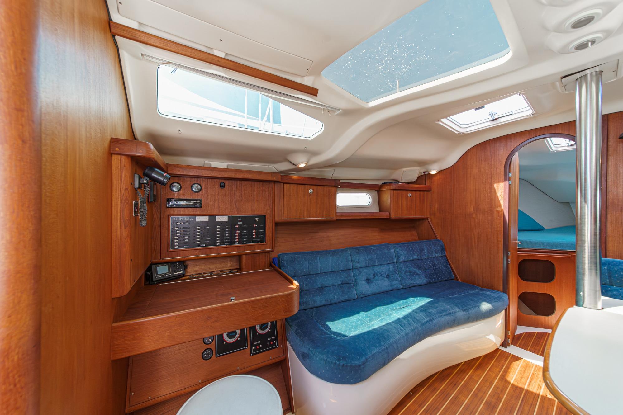 Interior of a 1996 Hunter 376 sailboat with wood paneling and blue seating.