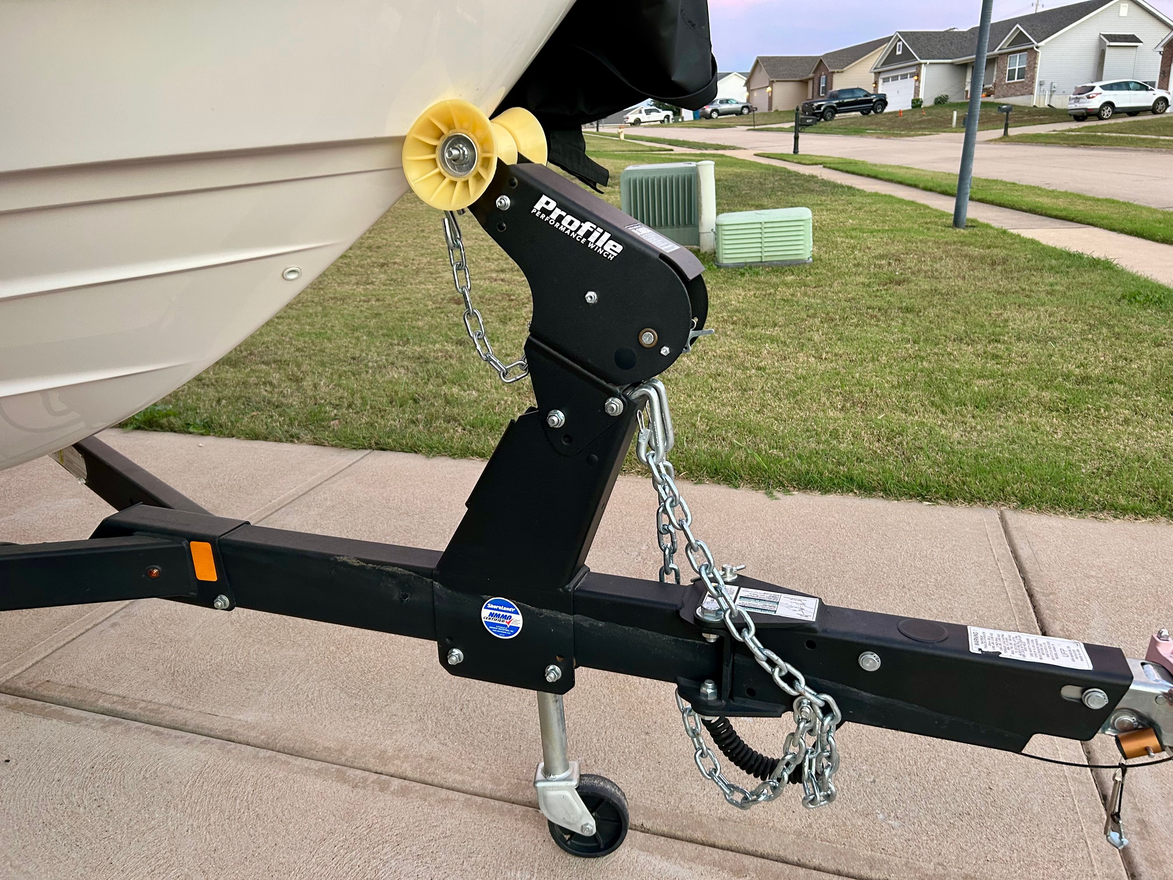 A Yamaha AR210 boat on a trailer in a residential area.