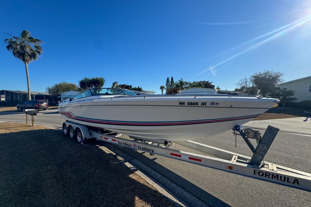 1989 Formula 292 SR-1 boat on trailer, parked in sunny residential area.