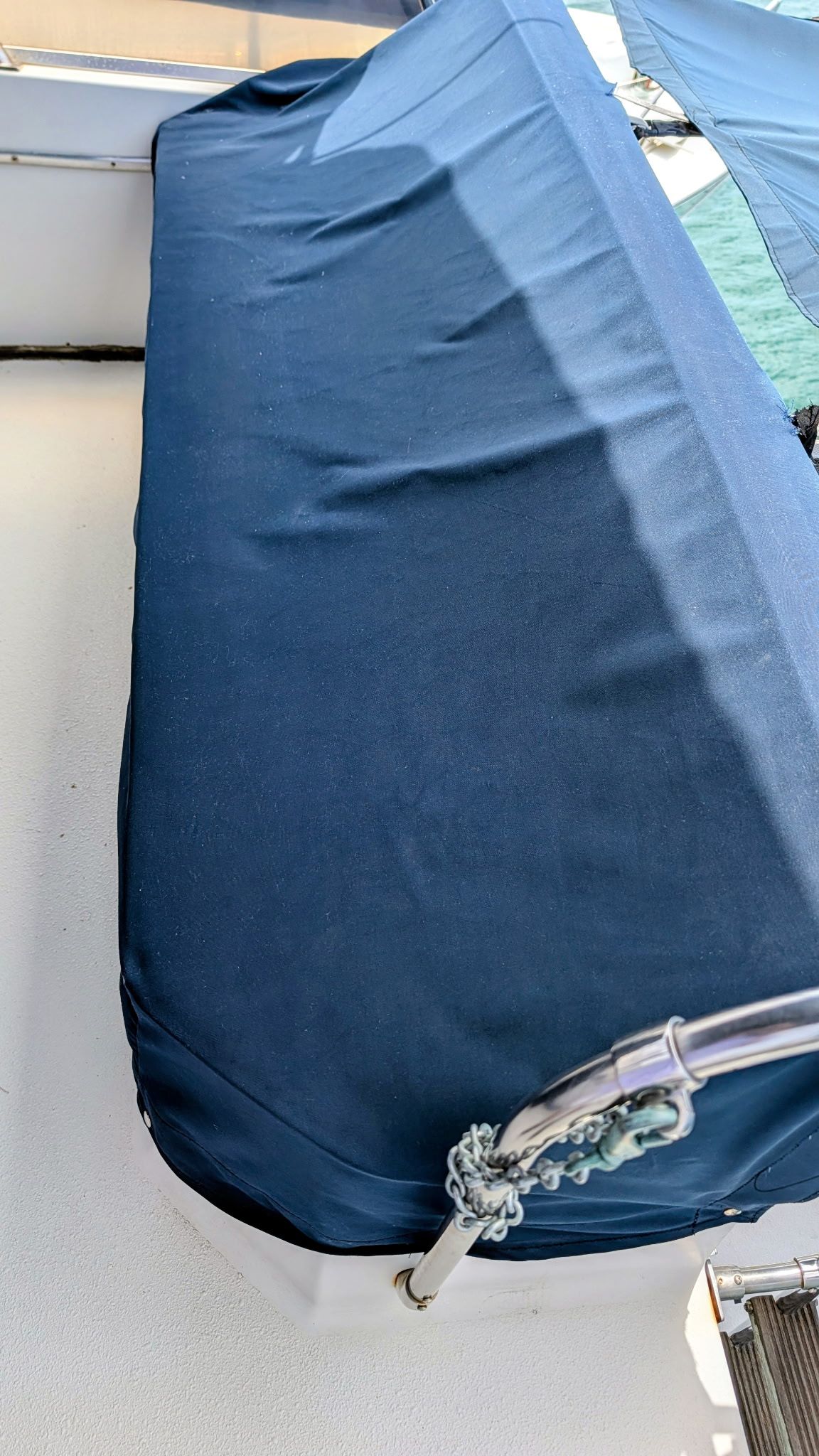 A seating area on a boat covered with a blue protective cover.