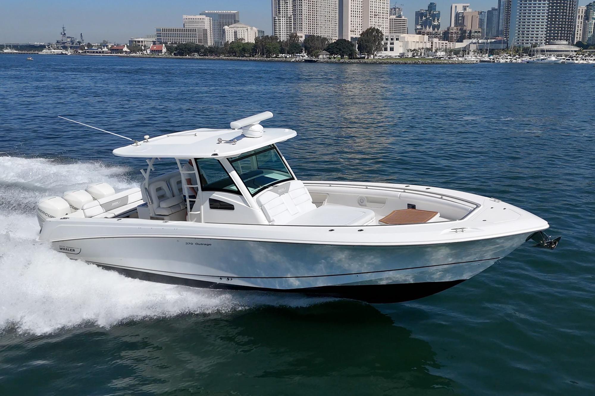 2015 Boston Whaler 370 Outrage cruising on water near city skyline.