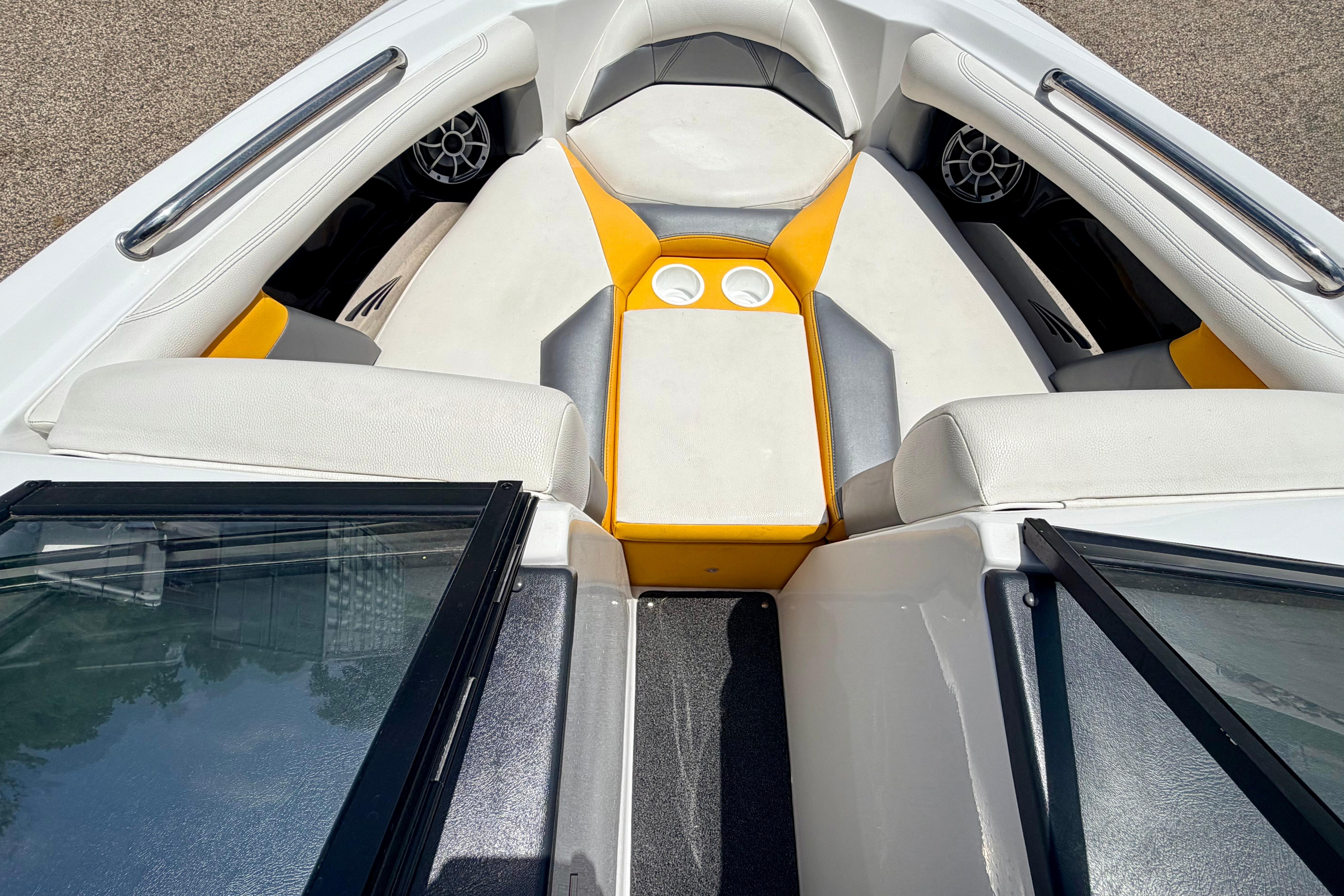 2014 Tigé R20 boat interior with white and yellow seating, cup holders, and speakers.